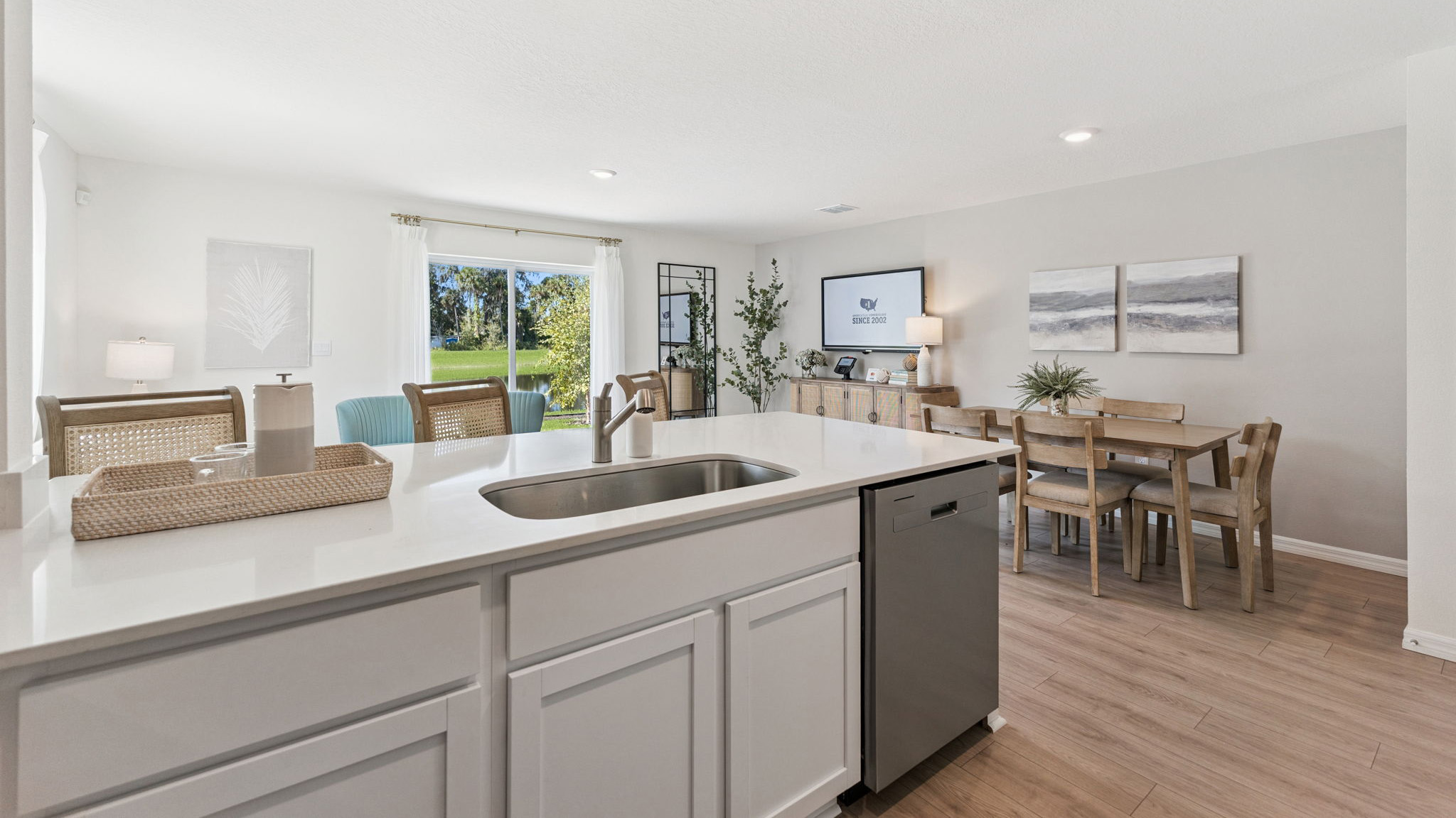 Kitchen with island seating, quartz counters, spacious pantry and stainless steel appliances.