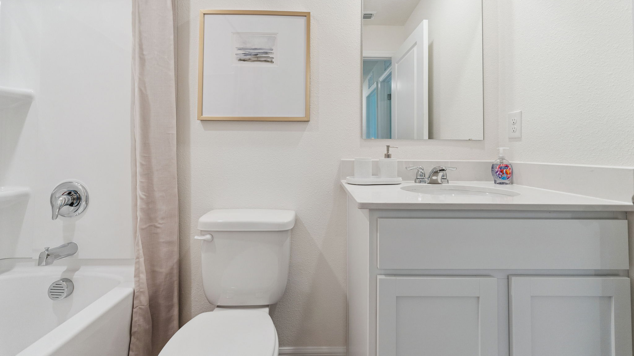 Modern bathroom with double vanity, large wall mirror, cabinets and quartz countertops