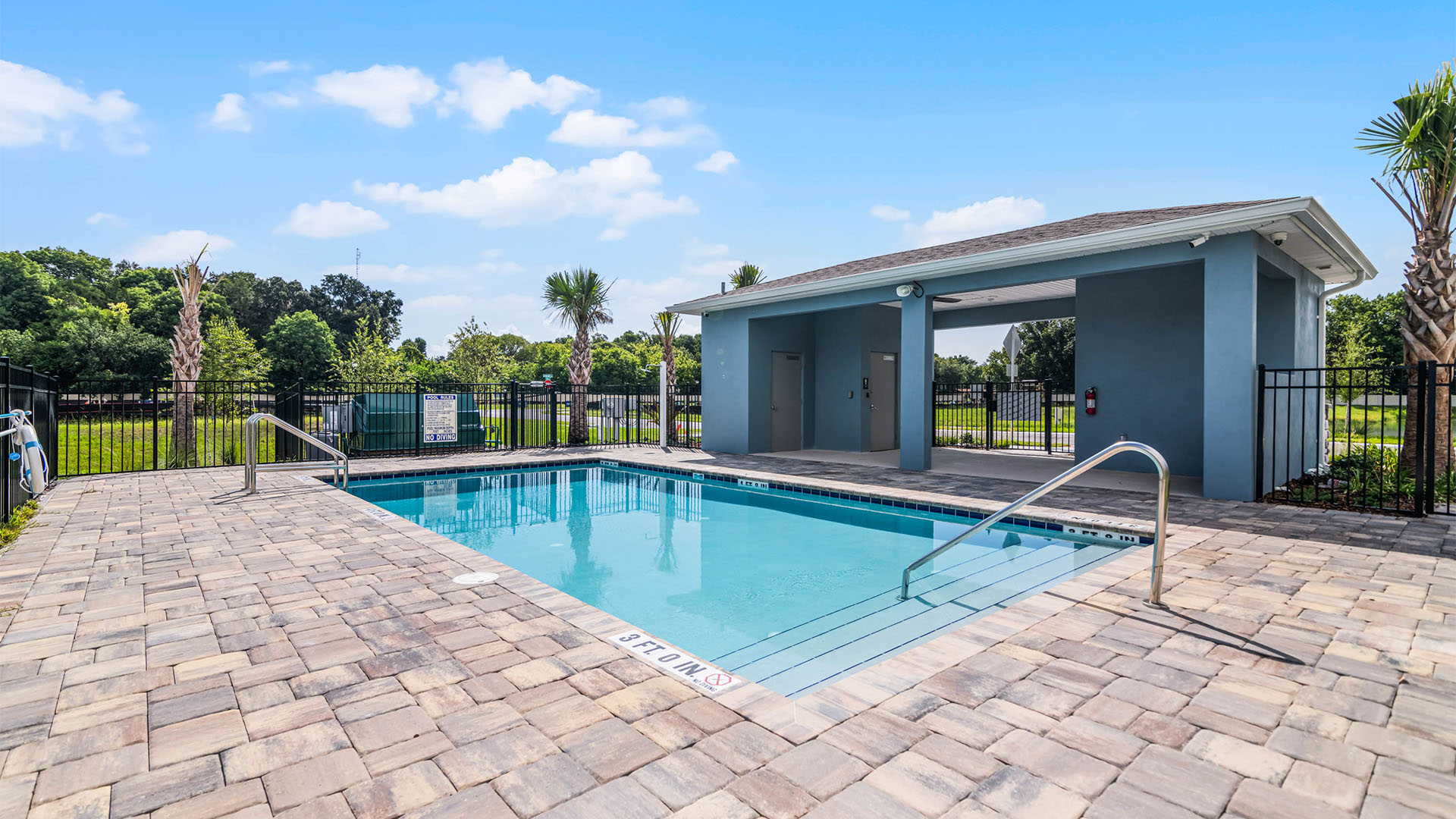 Sunny day at the community swimming pool with lounge seating.