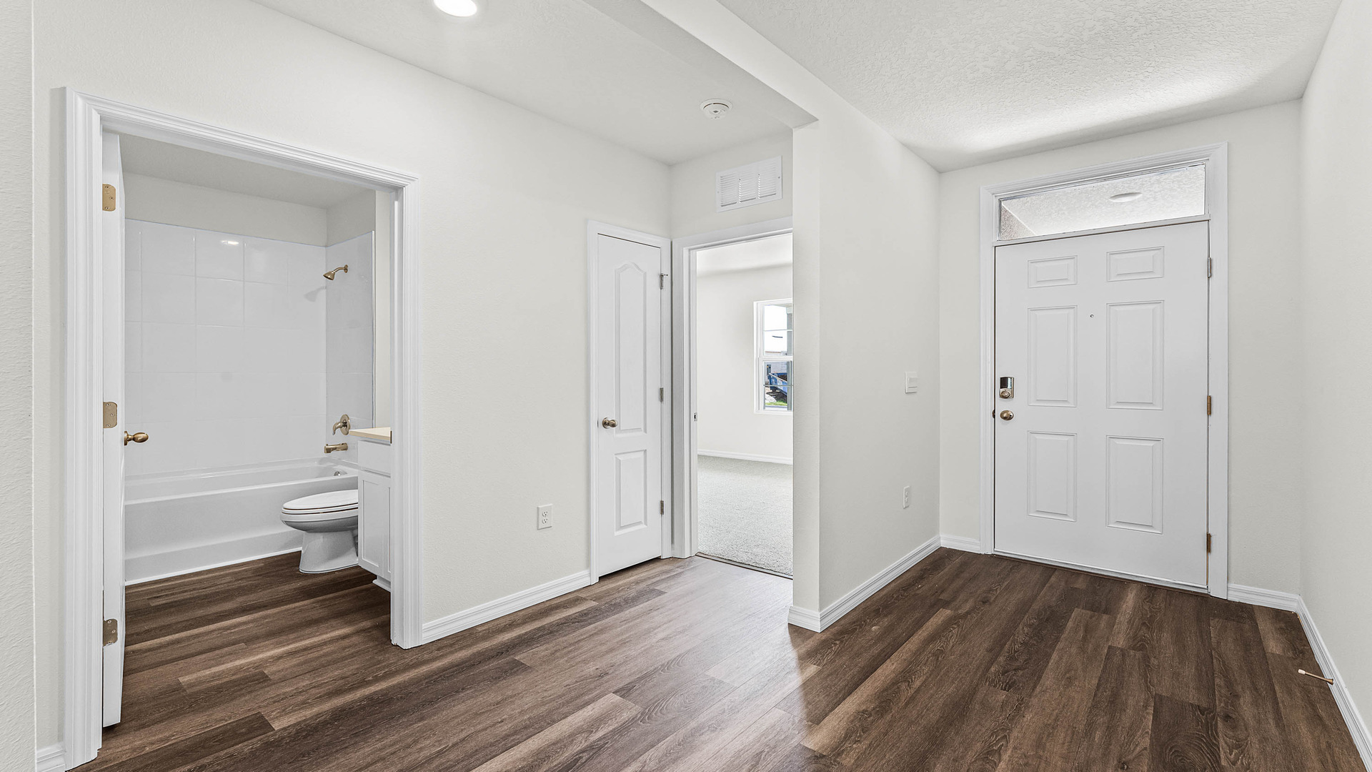 Home entry way thru the front door with tile flooring and a view to the living space.