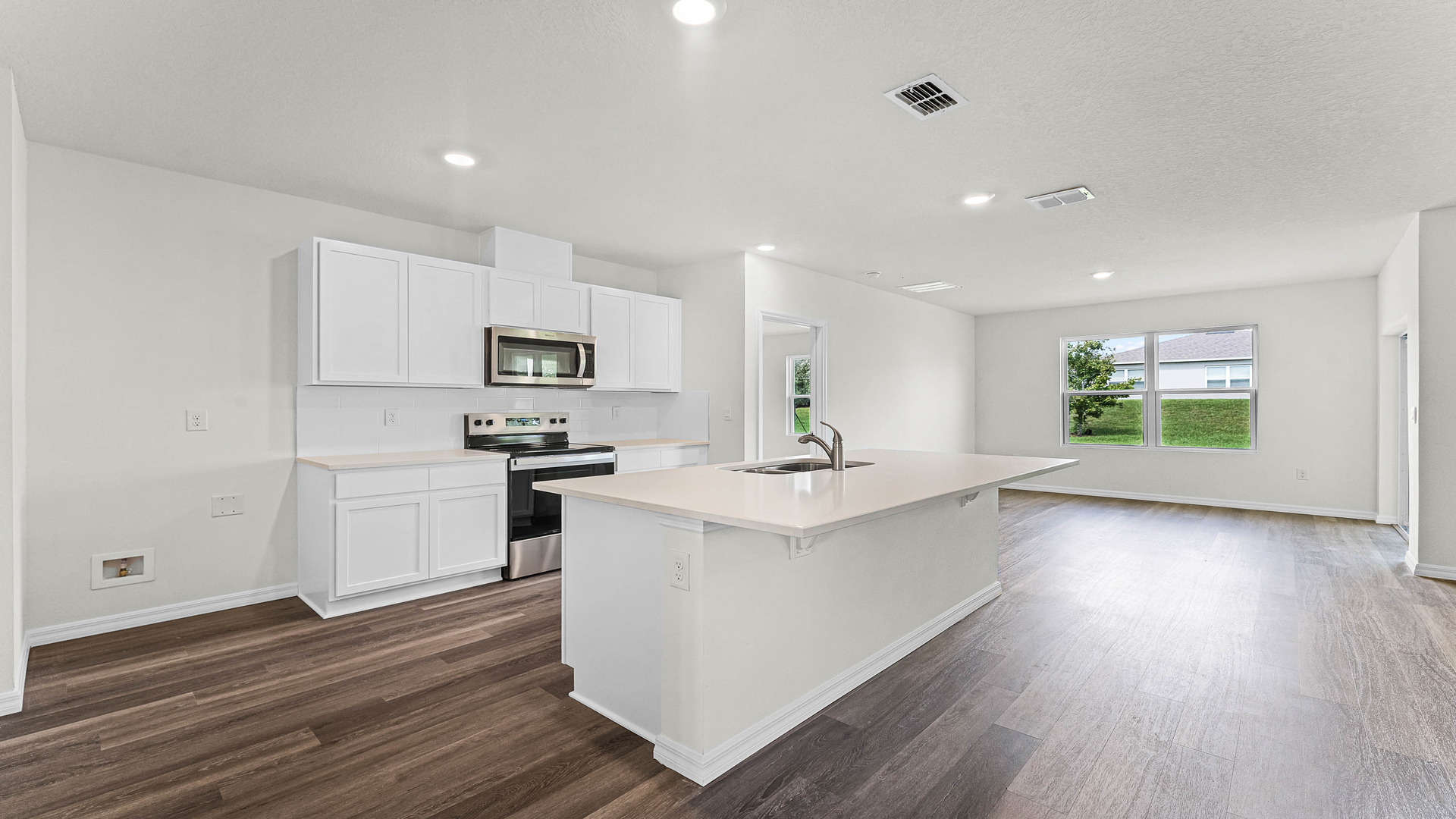 Kitchen with island seating, granite counters, spacious pantry and stainless-steel appliances.