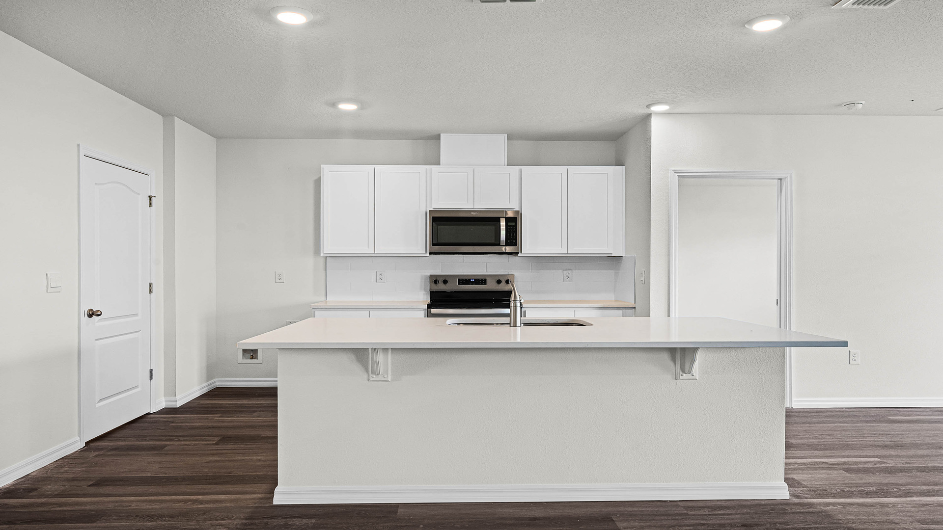 Kitchen with island seating, granite counters, spacious pantry and stainless-steel appliances.