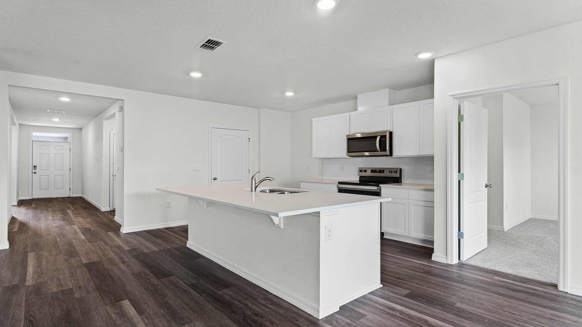 Kitchen with island seating, granite counters, spacious pantry and stainless-steel appliances.