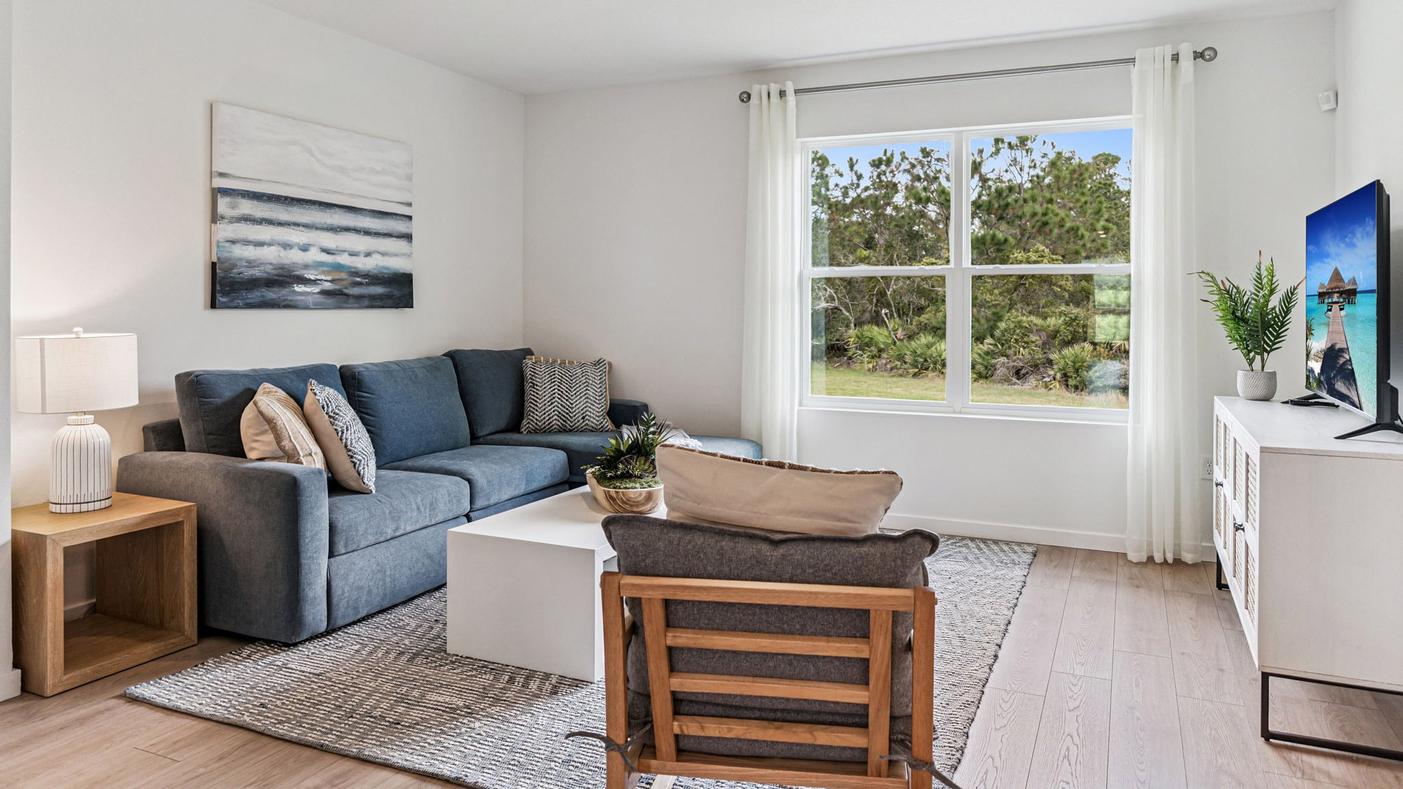 Living area with couch seating, entertainment system and natural lighting