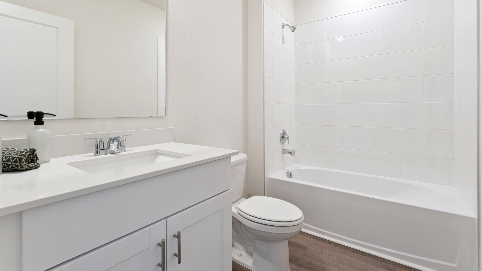 Modern bathroom with single vanity, large wall mirror, cabinets and quartz countertops