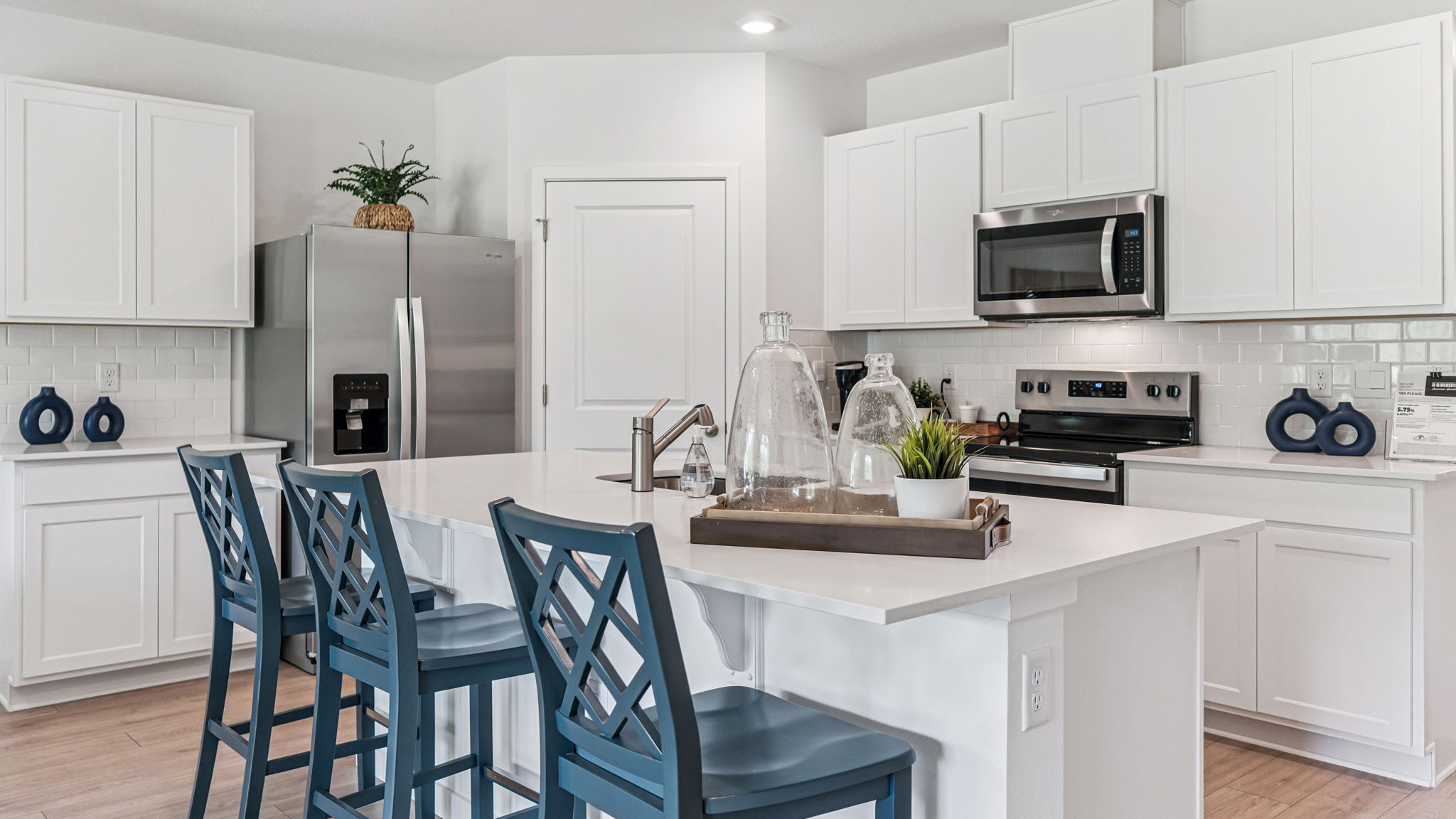 Kitchen with island seating, quartz counters, spacious pantry and stainless steel appliances