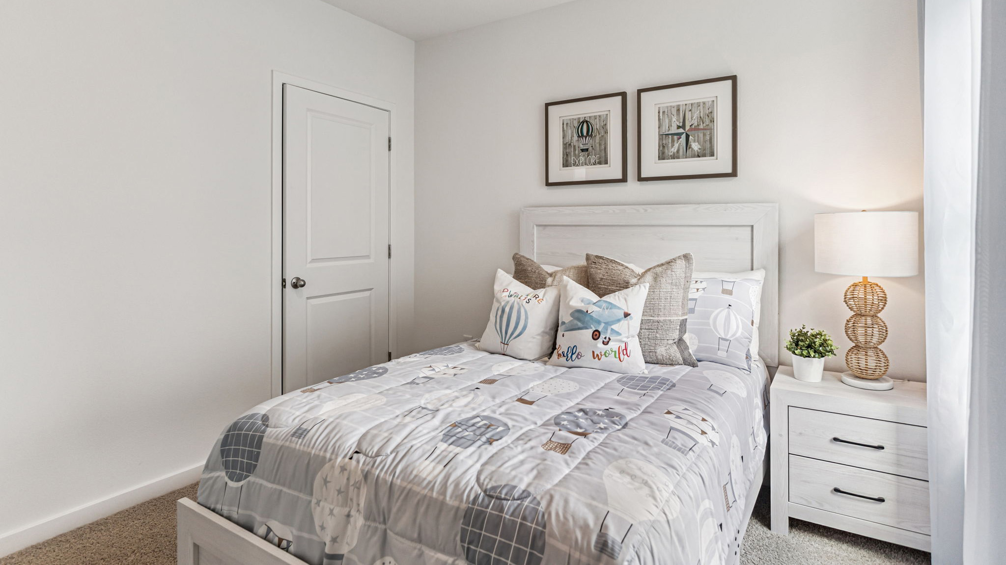 Spacious primary bedroom with king size bed, carpet flooring, natural lighting.