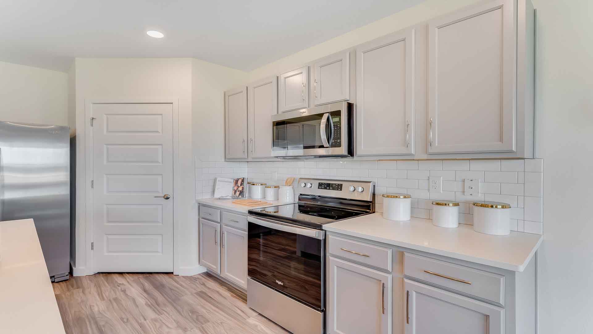 Kitchen with island seating, granite counters, spacious pantry and stainless-steel appliances.