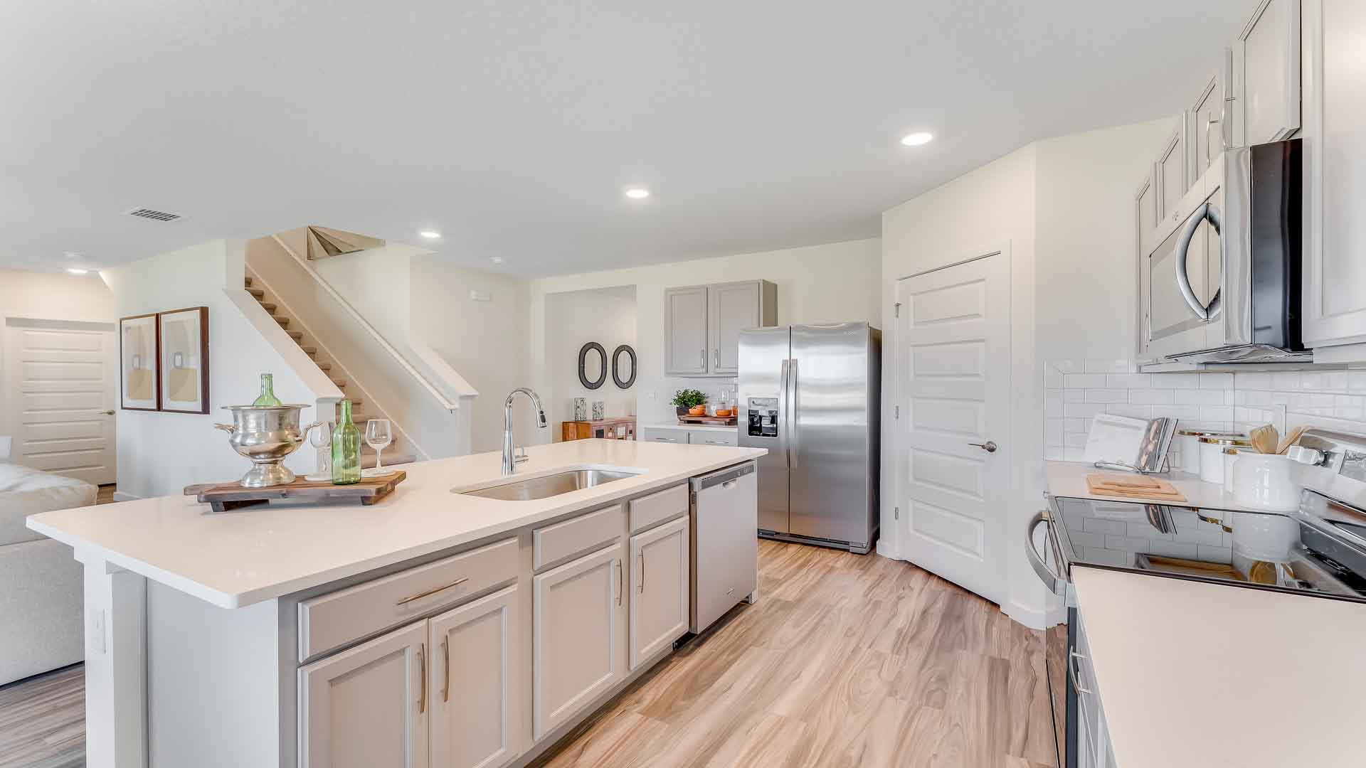 Kitchen with island seating, granite counters, spacious pantry and stainless-steel appliances.