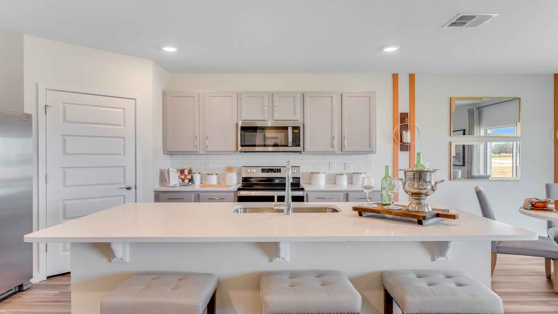Kitchen with island seating, granite counters, spacious pantry and stainless-steel appliances.