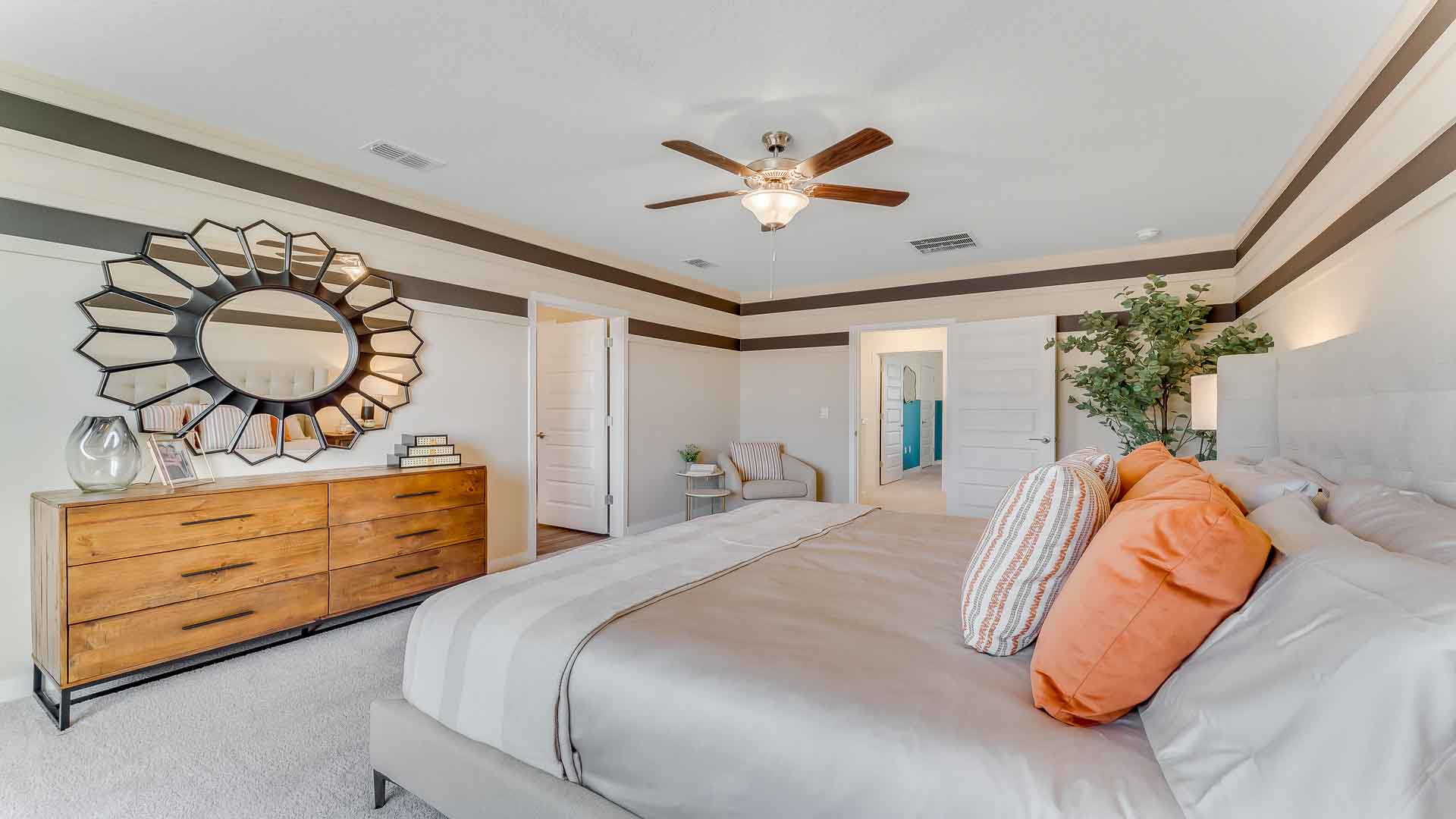 Spacious primary bedroom with king size bed, carpet flooring, natural lighting and a walk in closet.