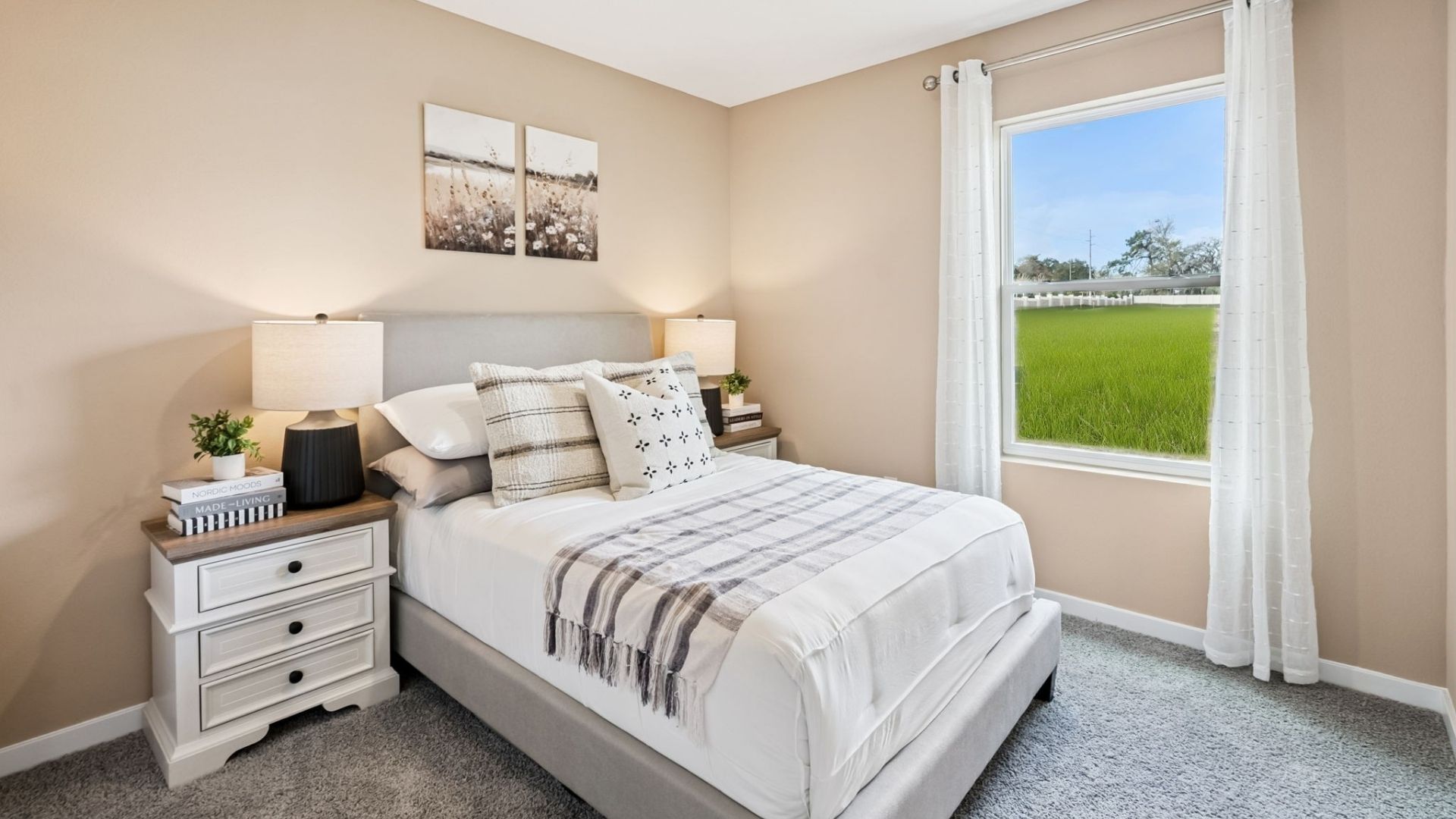 Spacious primary bedroom with king size bed, carpet flooring, natural lighting.