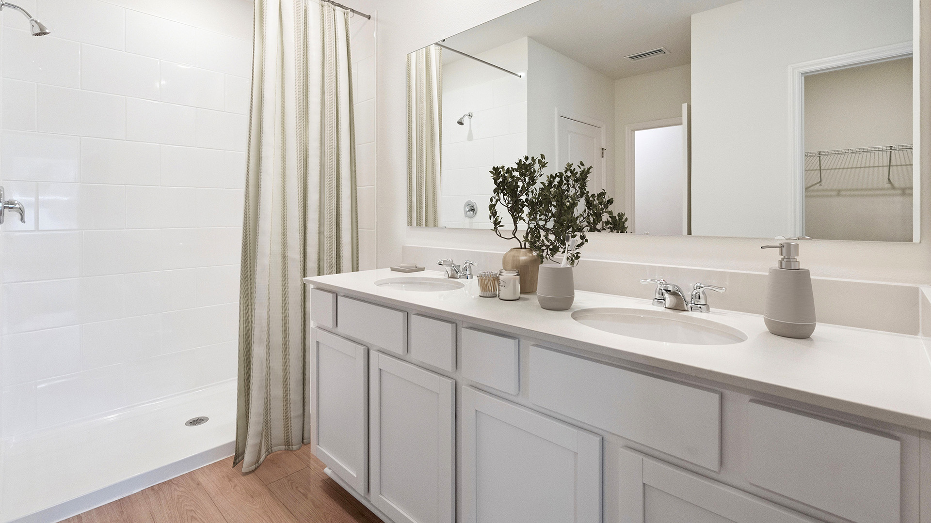 Modern bathroom with single vanity, large wall mirror, cabinets and quartz countertops