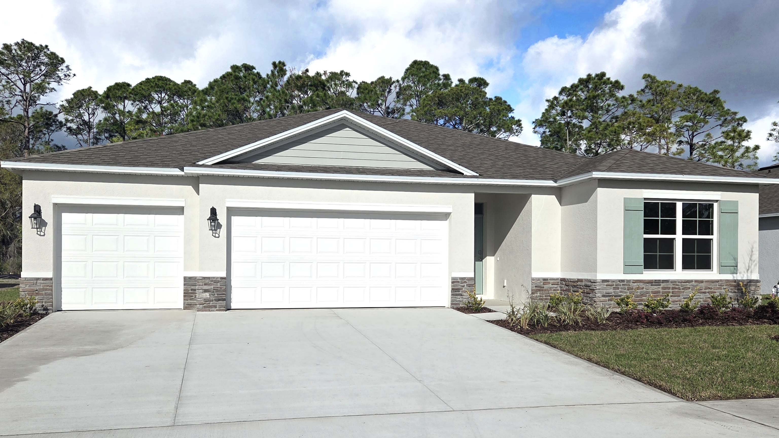 Single story new home with large windows and 2 car garage.