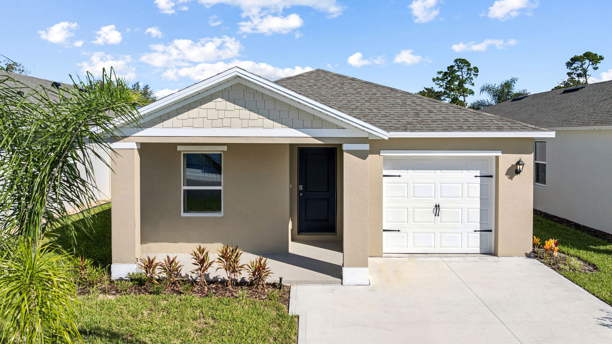 Single story new home with large windows and 2 car garage.