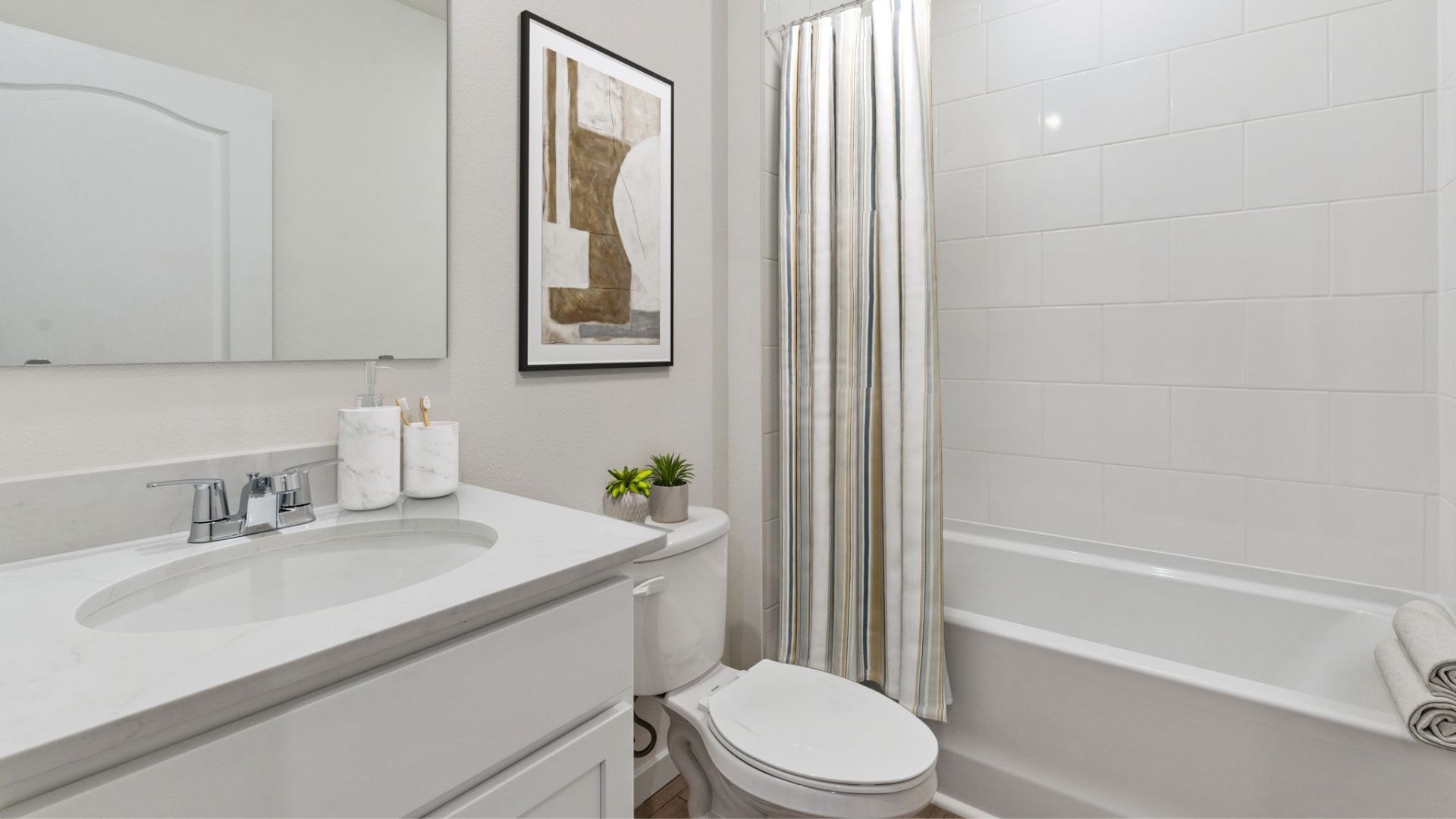 Modern bathroom with double vanity, large wall mirror, cabinets and quartz countertops