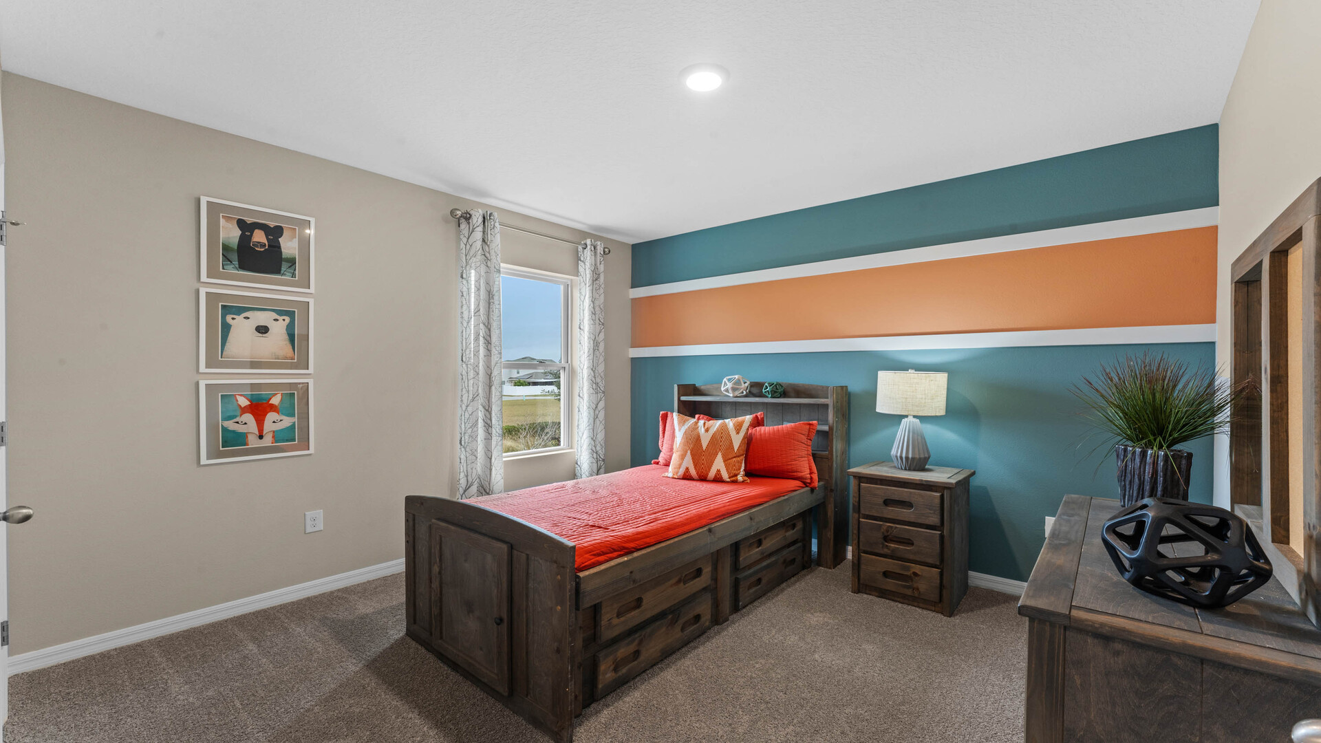 Spacious primary bedroom with king size bed, carpet flooring, natural lighting.