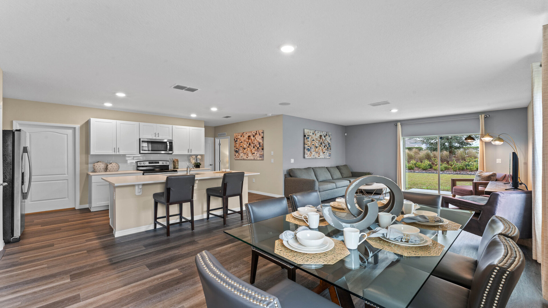 Living area with couch seating, entertainment system and natural lighting.