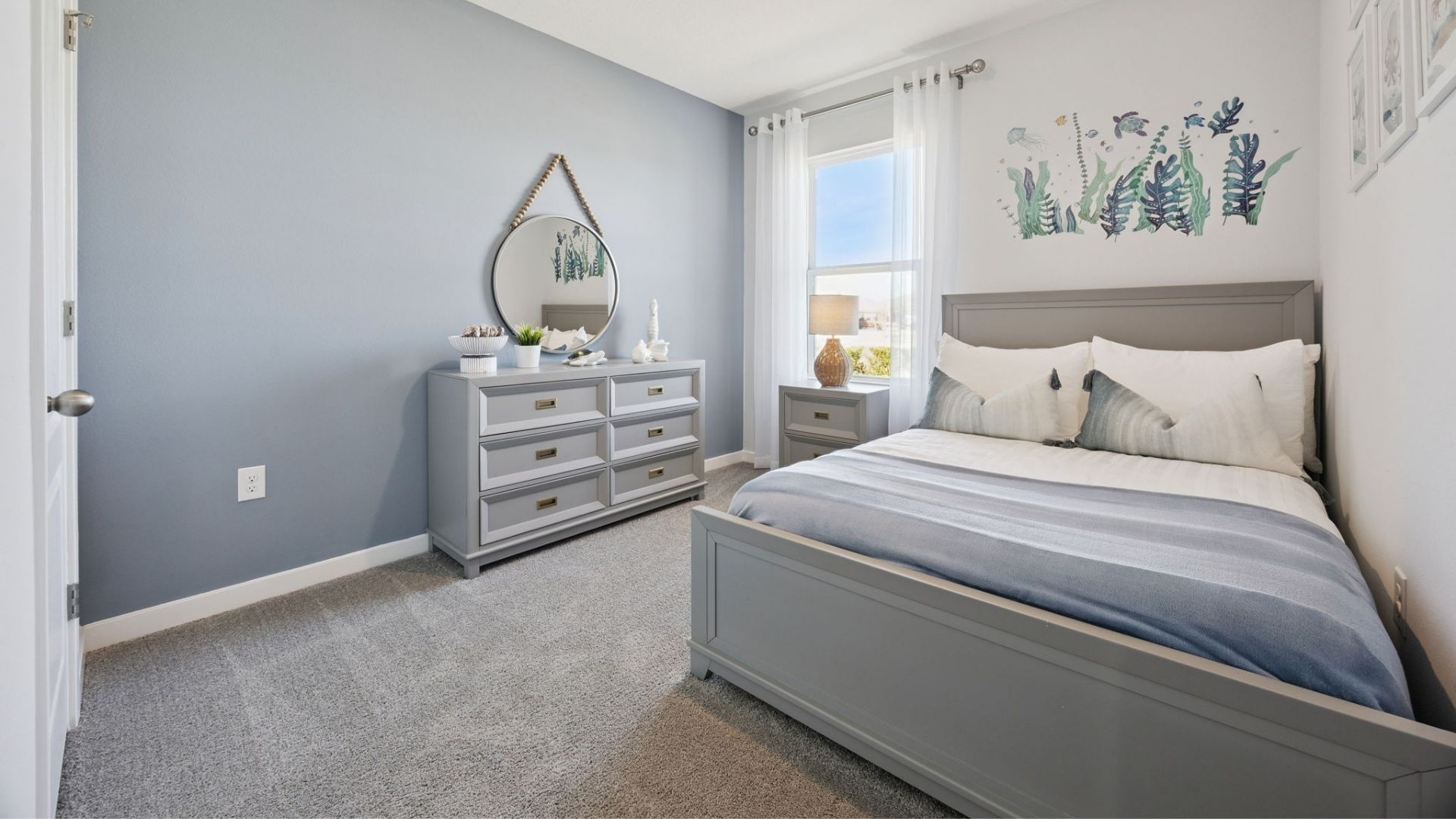 Guest bedroom with bed, nighstand, desk, and natural lighting with spacious closet.