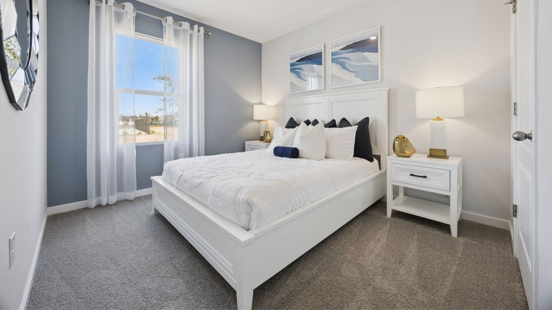Guest bedroom with bed, nighstand, desk, and natural lighting with spacious closet.