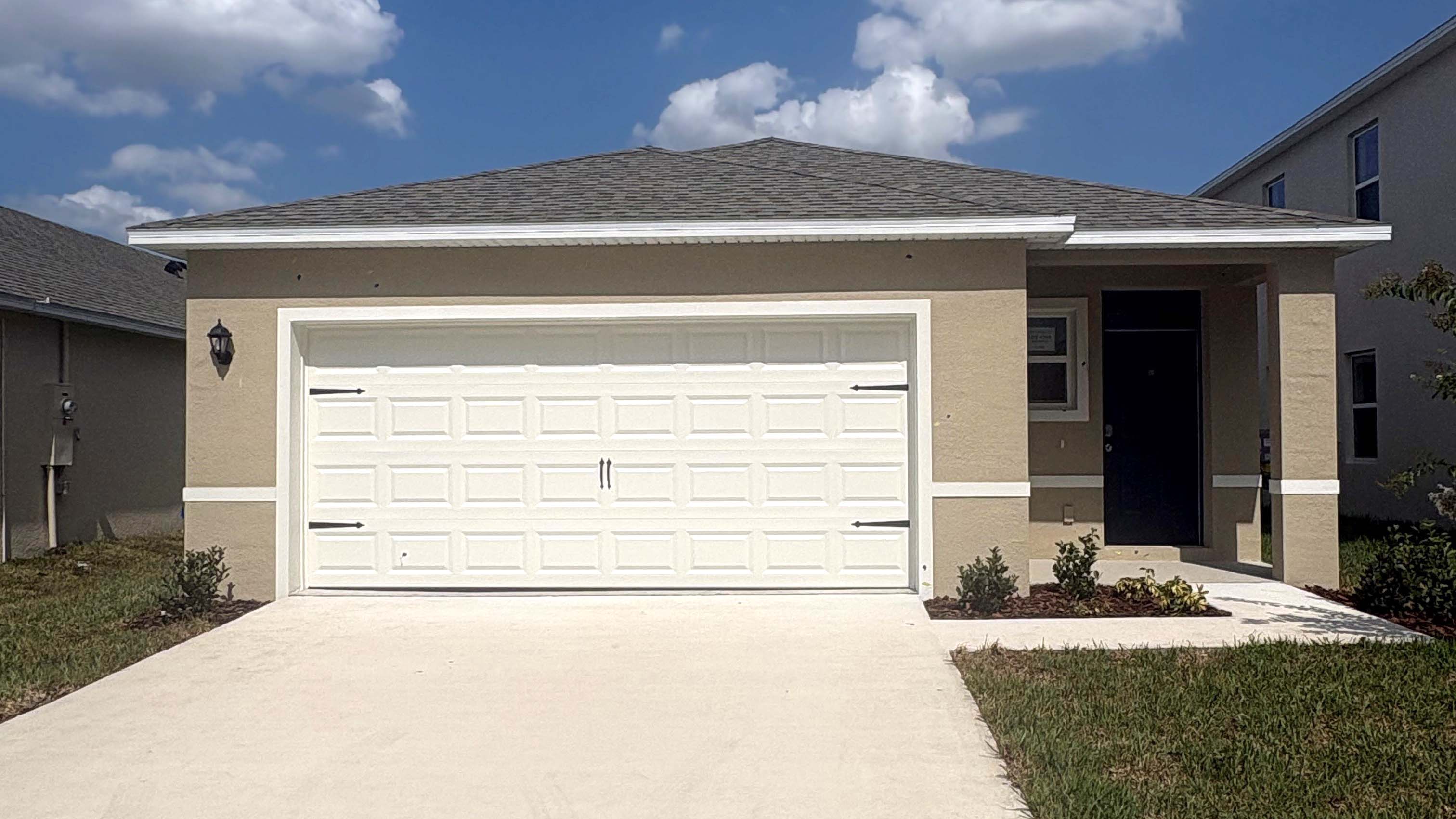 Single story new home with large windows and 2 car garage.