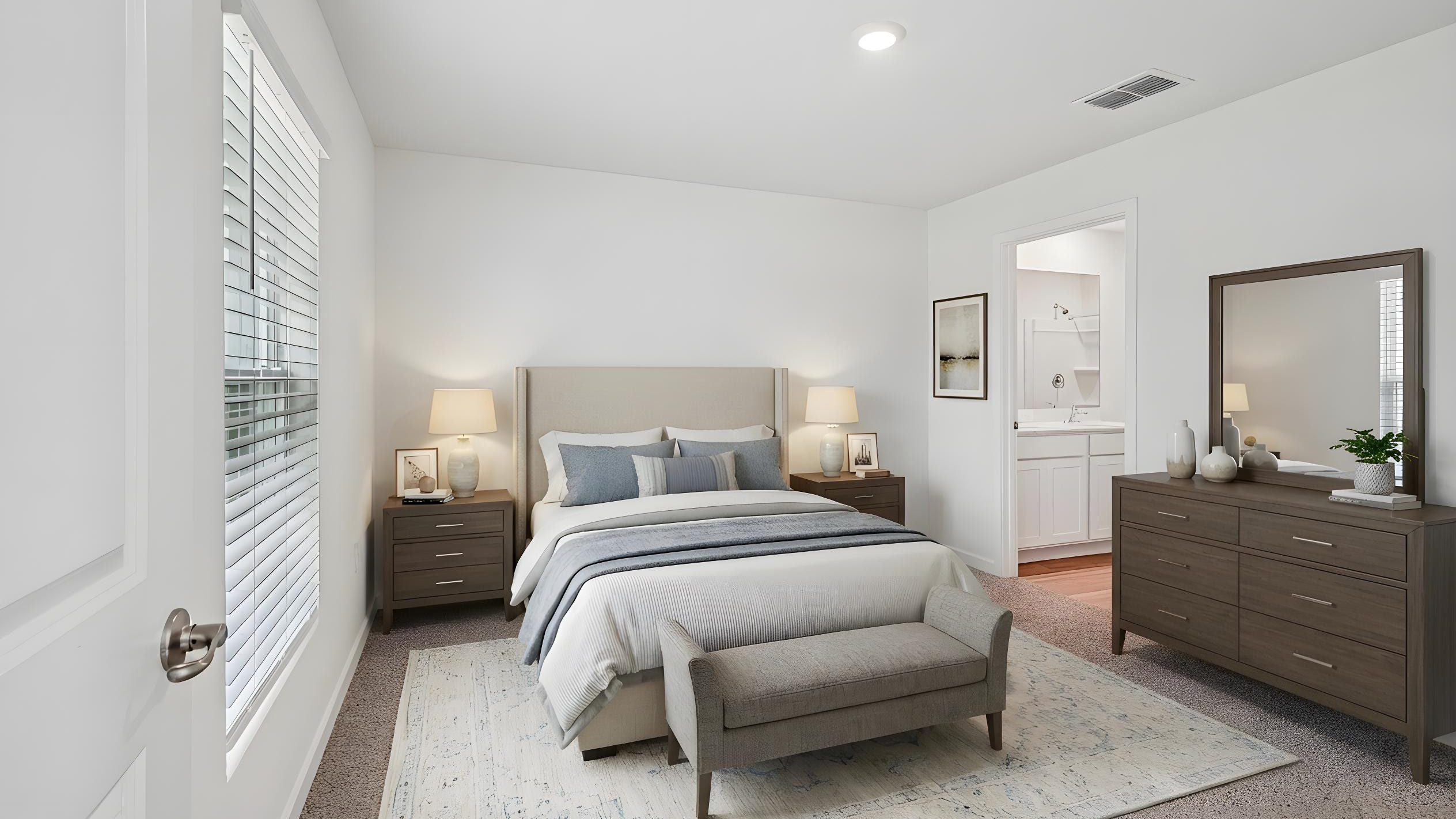 Spacious primary bedroom with king size bed, carpet flooring, natural lighting.