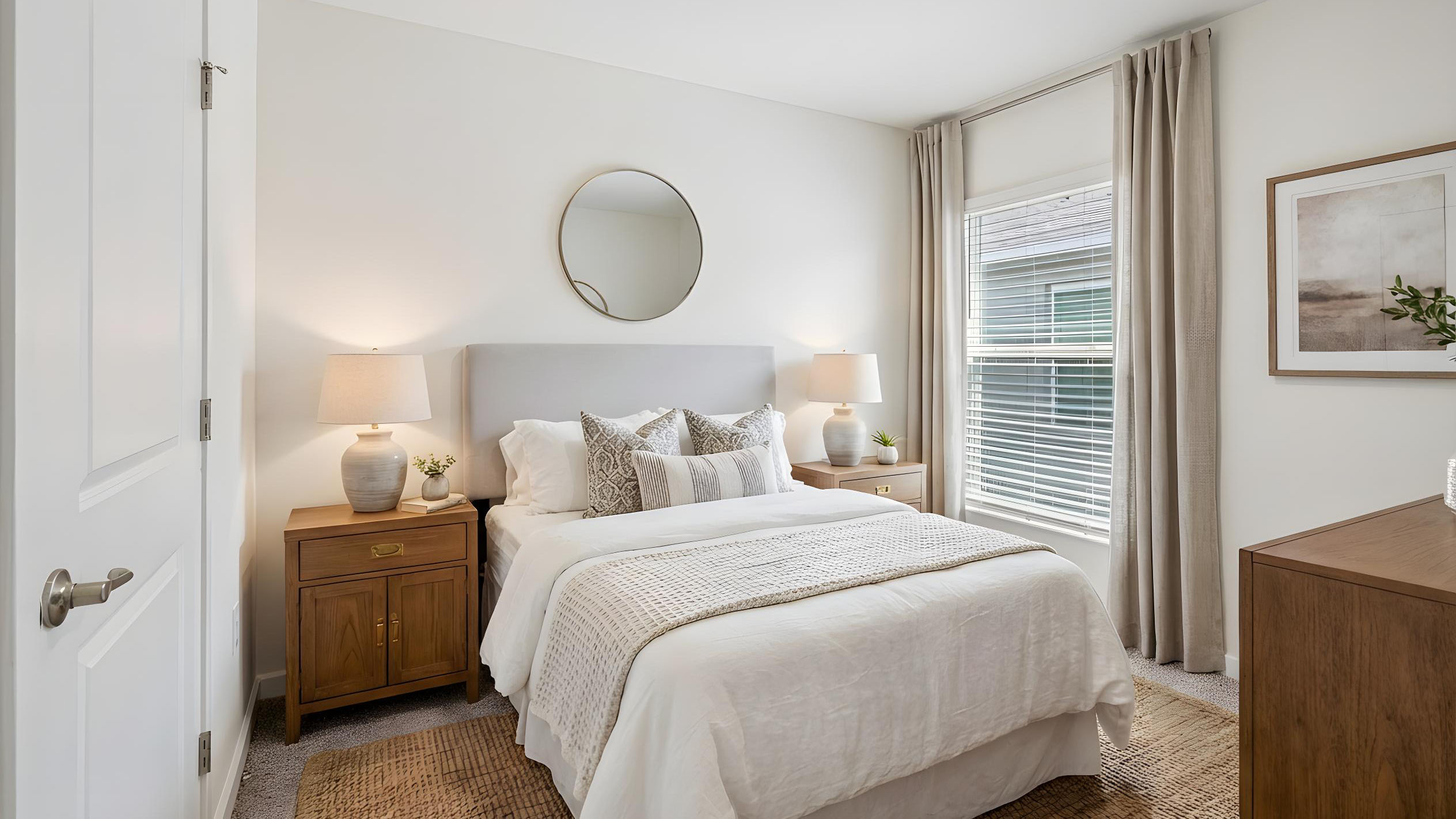 Spacious primary bedroom with bed, carpet flooring, natural lighting showing access to primary bathroom.