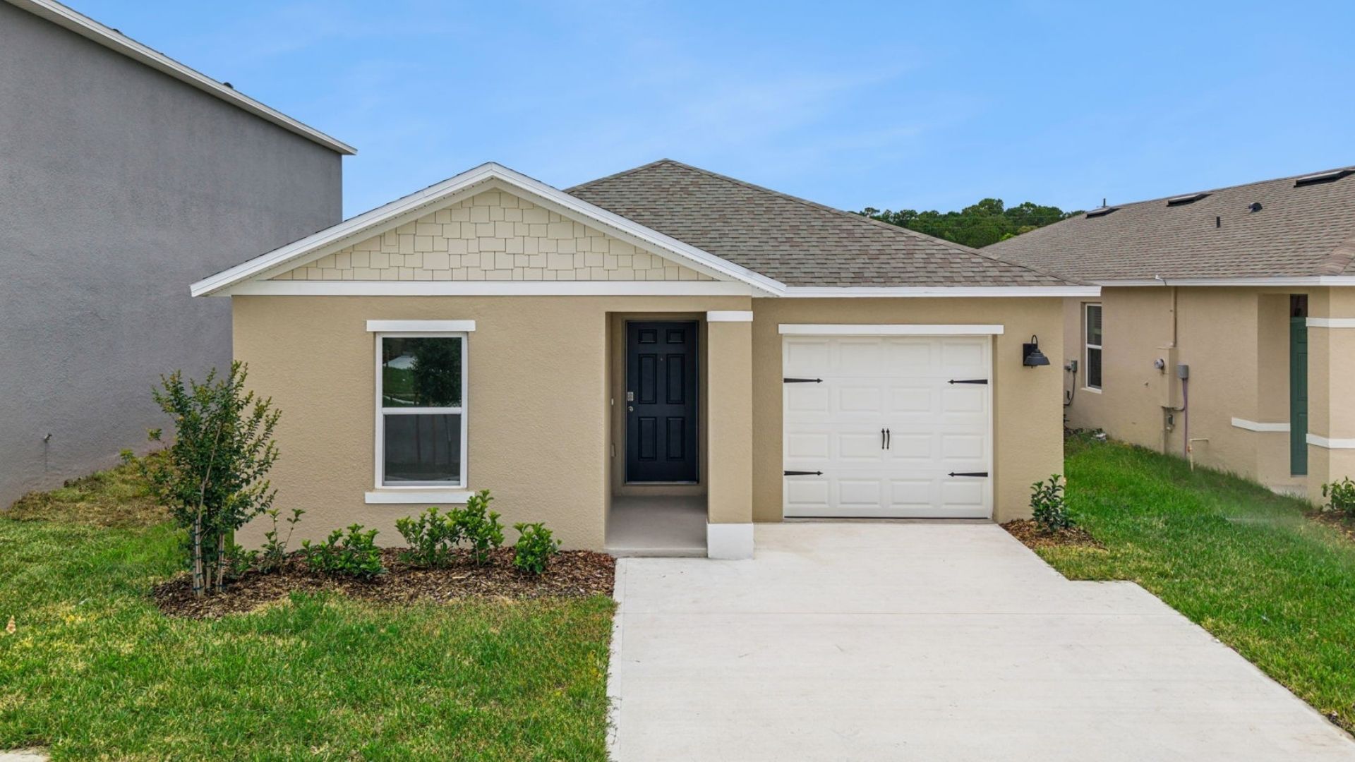 Single story new home with large windows and 2 car garage.