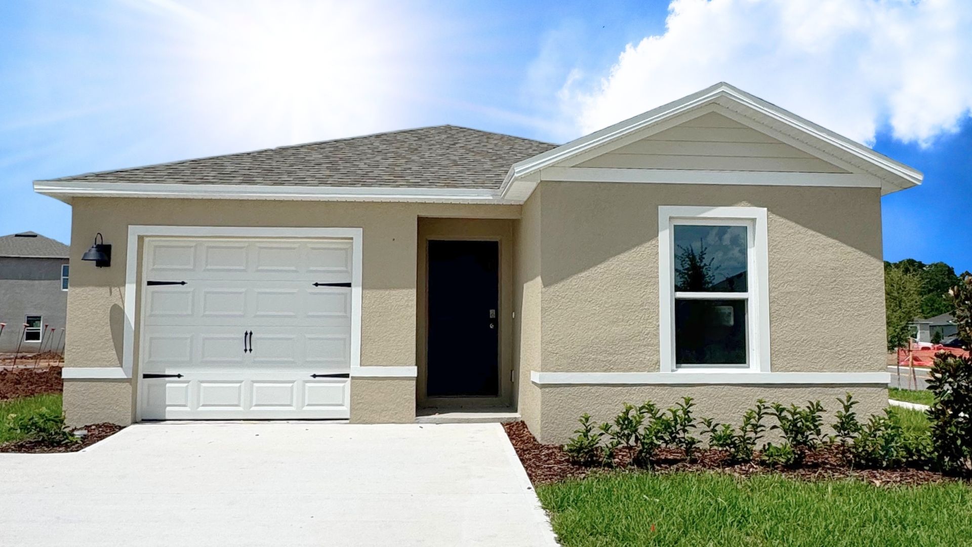 Single story new home with large windows and 2 car garage.