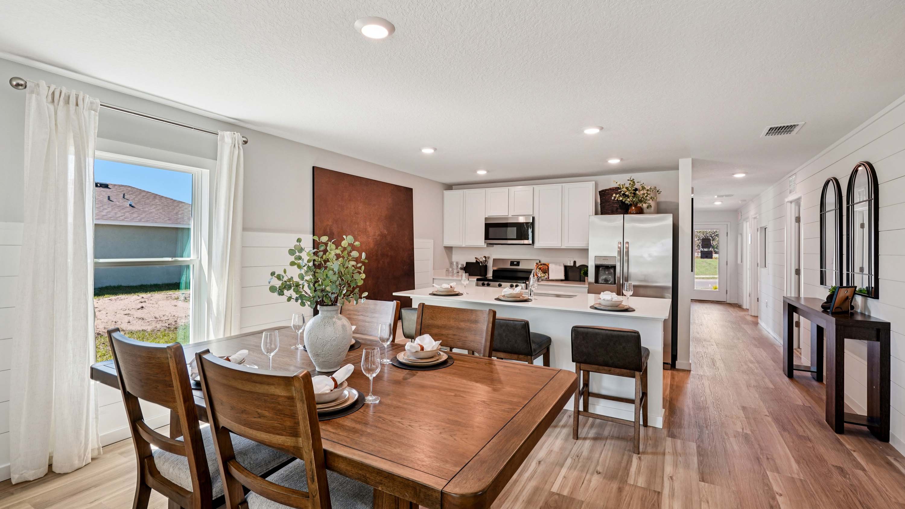 Dining room area with table, seating and natural lighting.