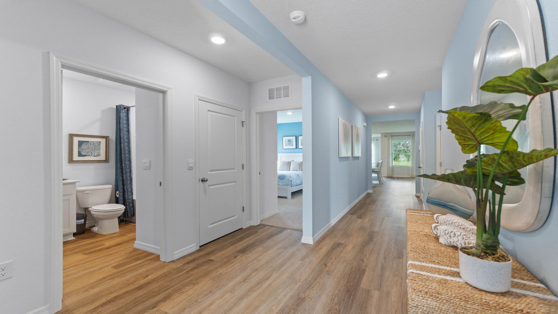 Entry way with luxury vinyl plank flooring showing hallway to rooms.