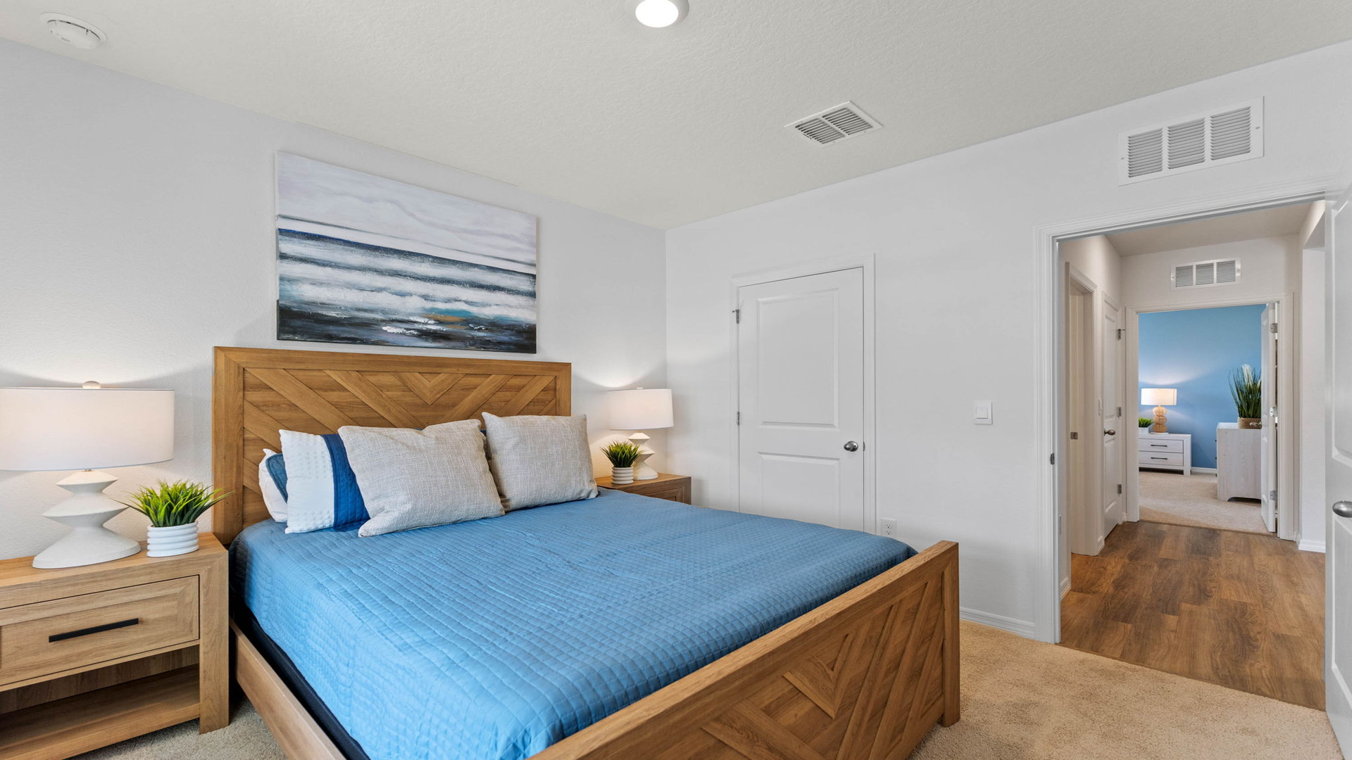 Guest bedroom with bed, nighstand, desk, and natural lighting with spacious closet.