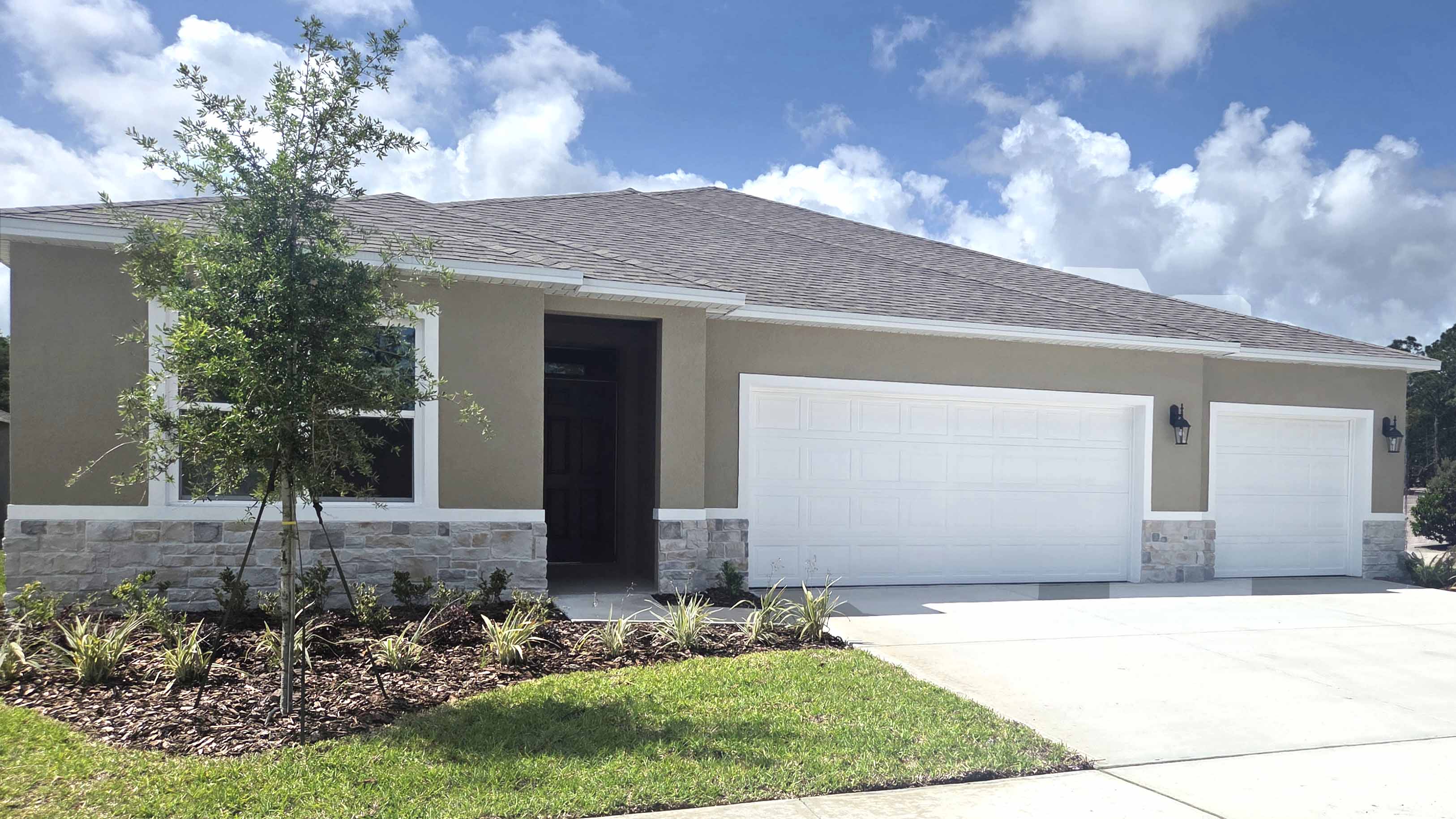 Single story new home with large windows and 2 car garage.