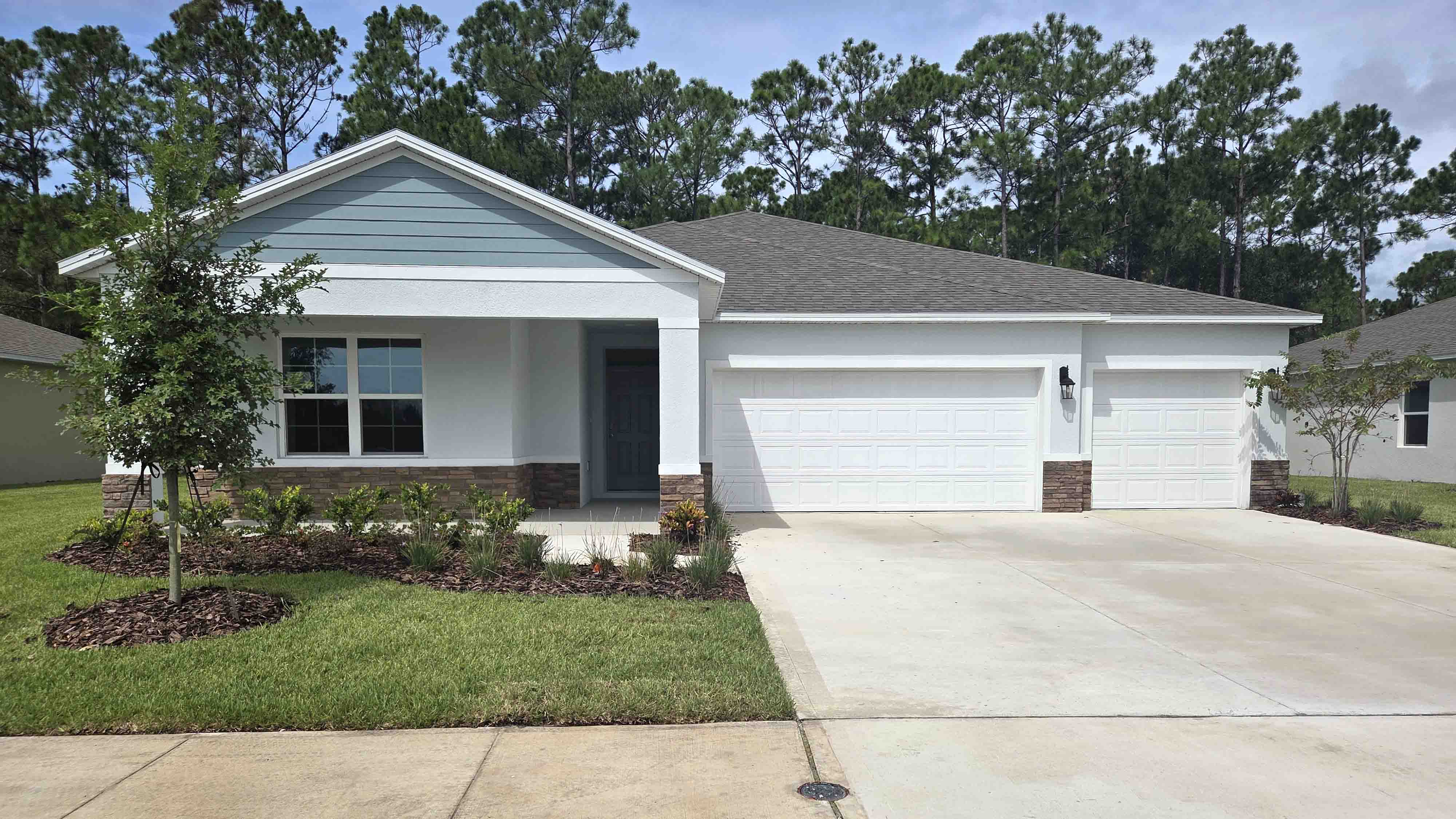 Single story new home with large windows and 2 car garage.