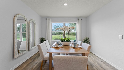 Dining room area with table, seating and natural lighting.