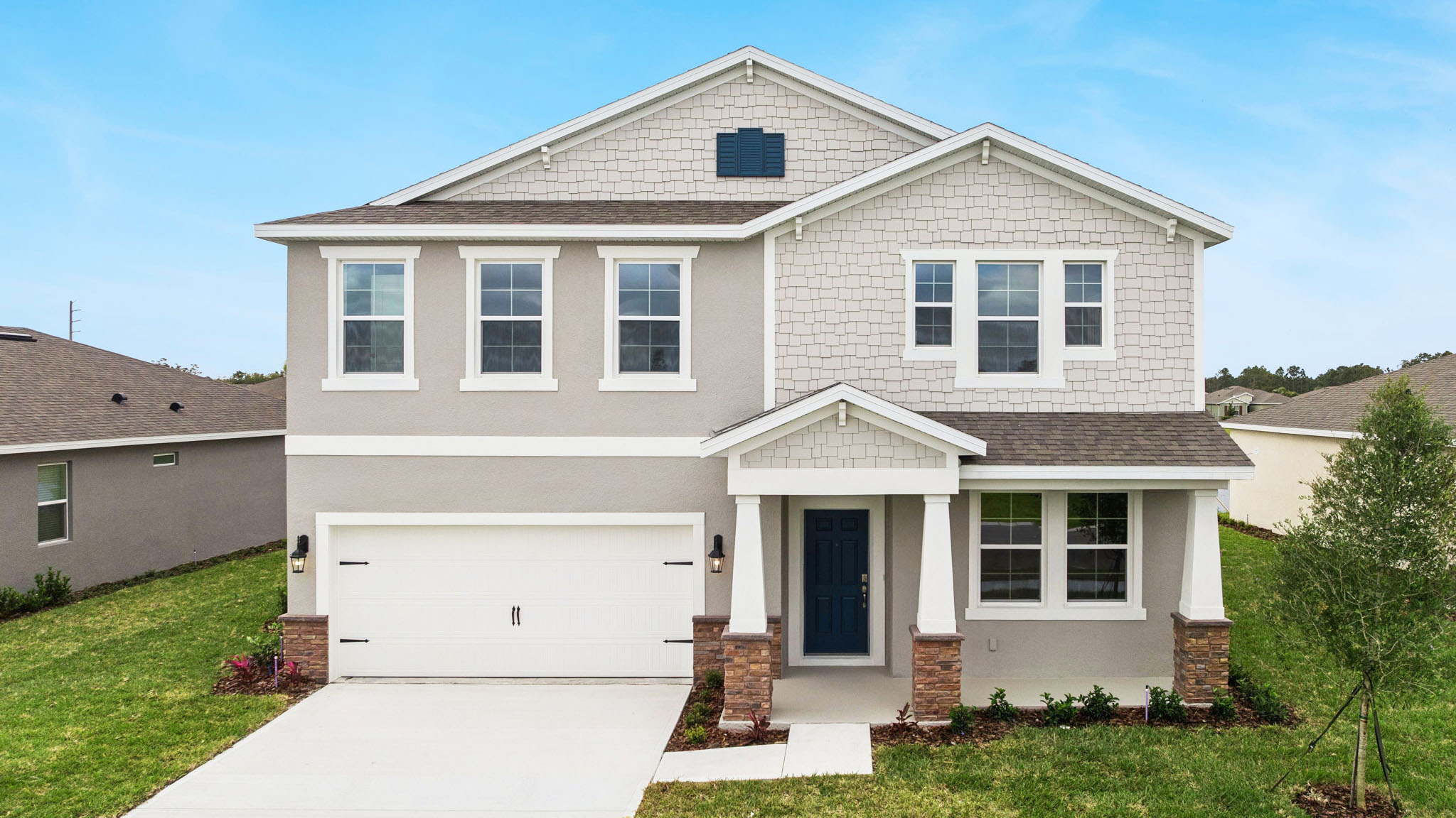 two story new home with large windows and 2 car garage.