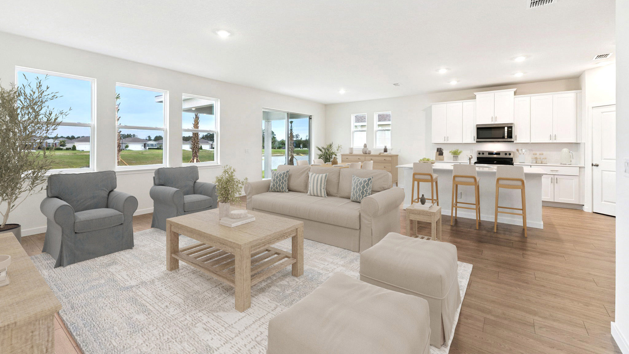 Living area with couch seating, natural lighting, laminate flooring.