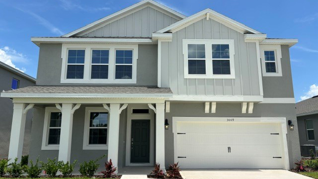 Two story new home with large windows and 2 car garage.