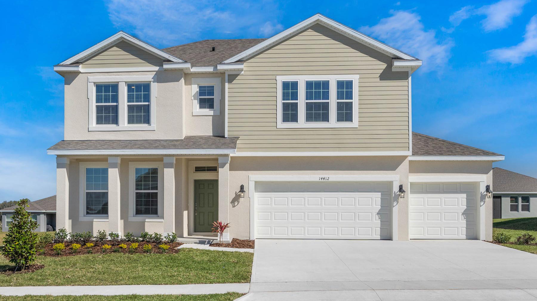 two story new home with large windows and 2 car garage.