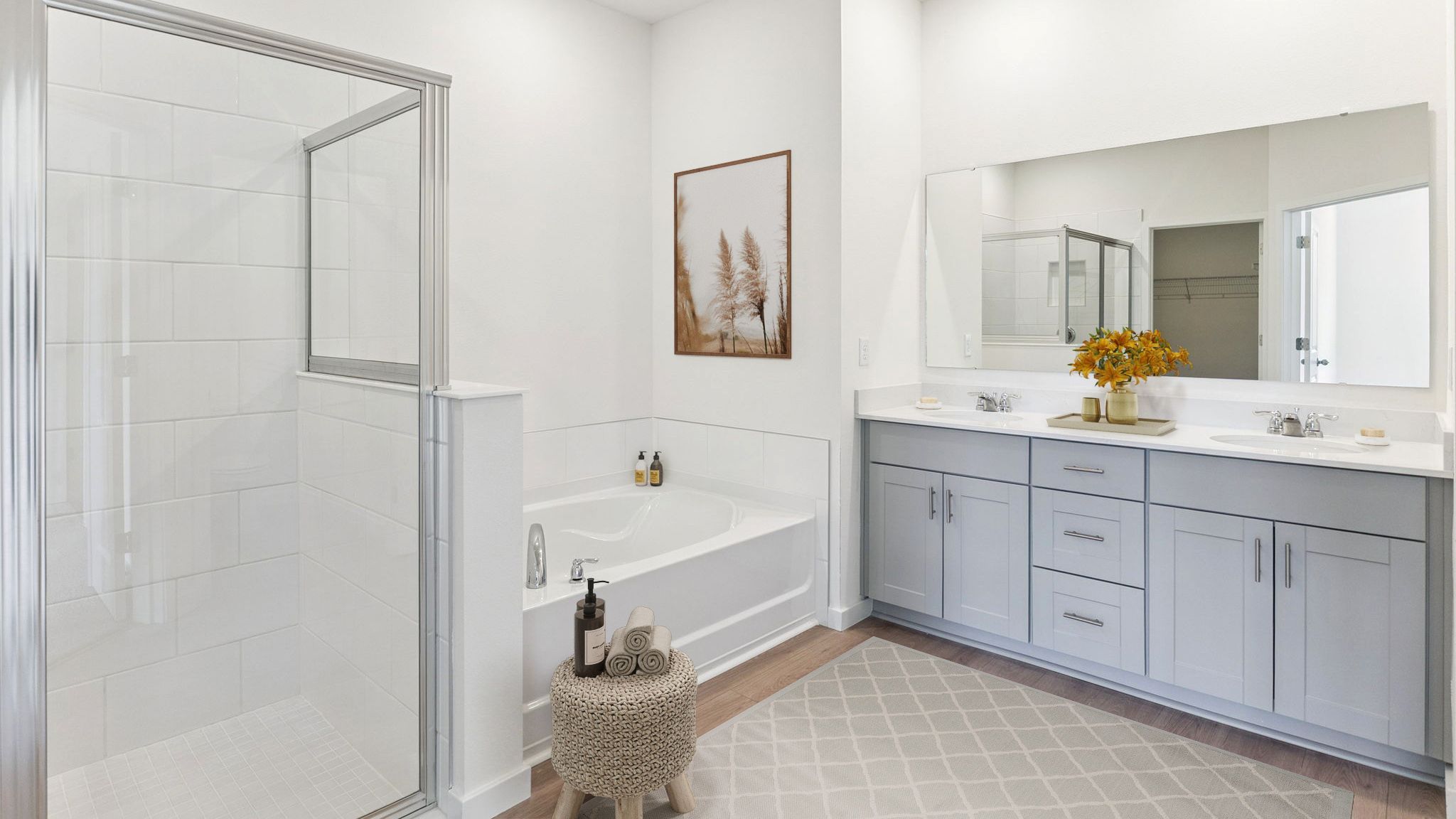 master bathroom showing double vanity with quartz countertops with access to walk-in closet.