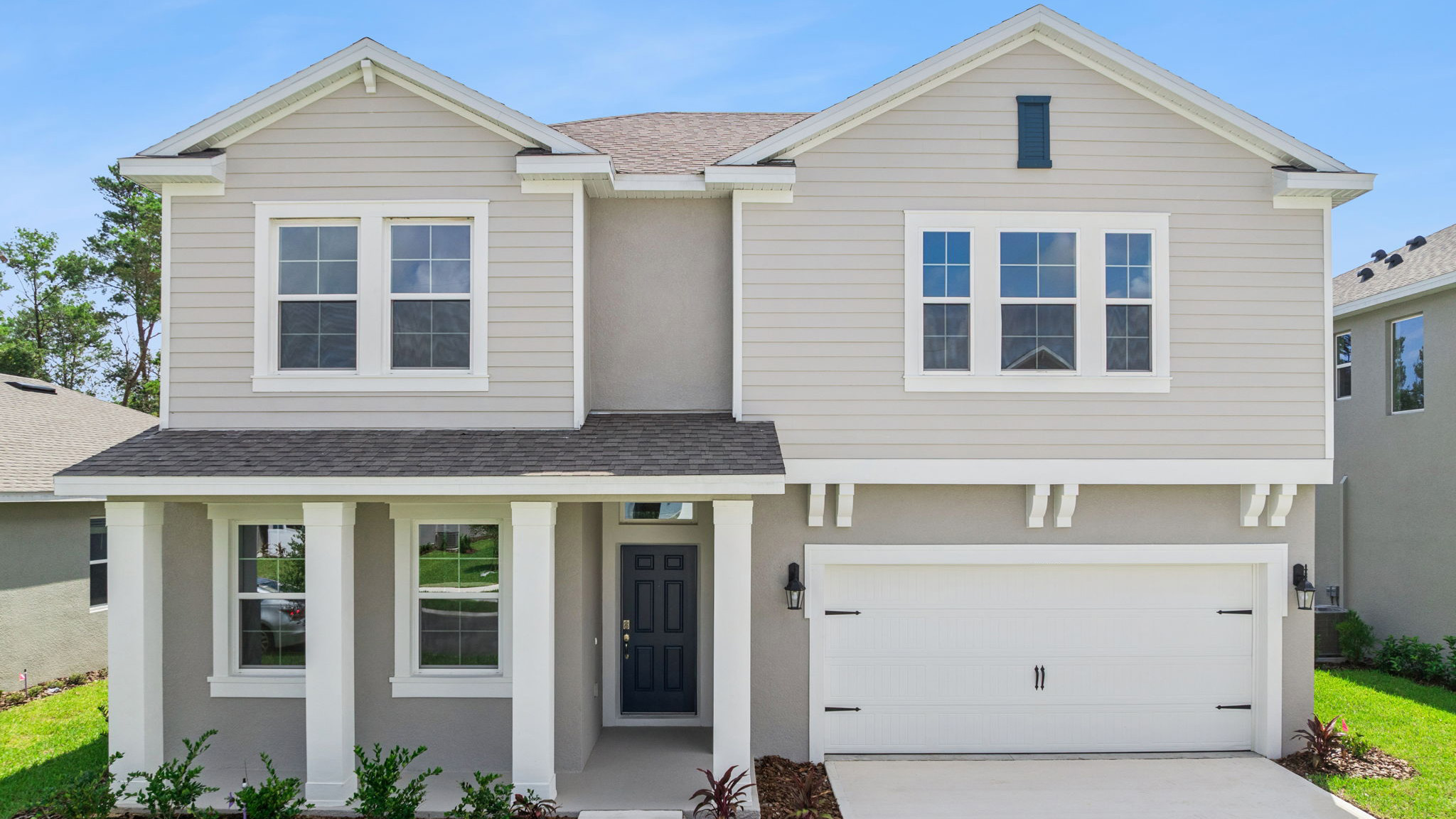 two story new home with large windows and 2 car garage.