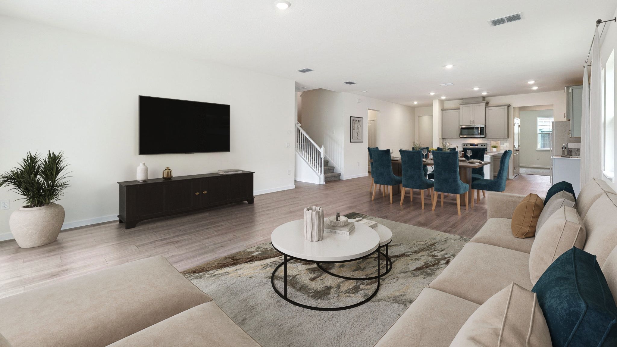 Living area with couch seating, natural lighting, laminate flooring.