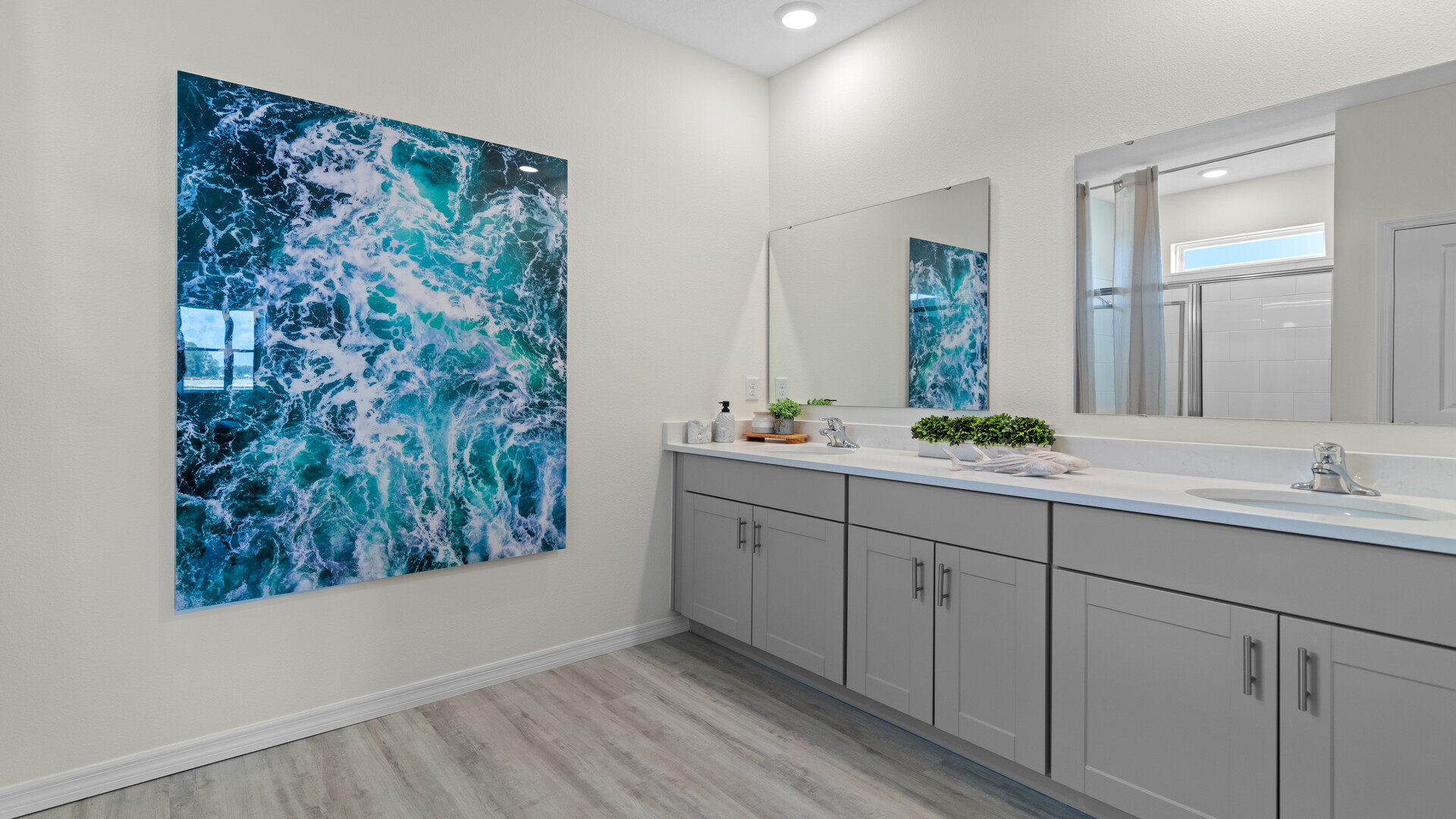 Modern bathroom with single vanity, large wall mirror, cabinets and quartz countertops
