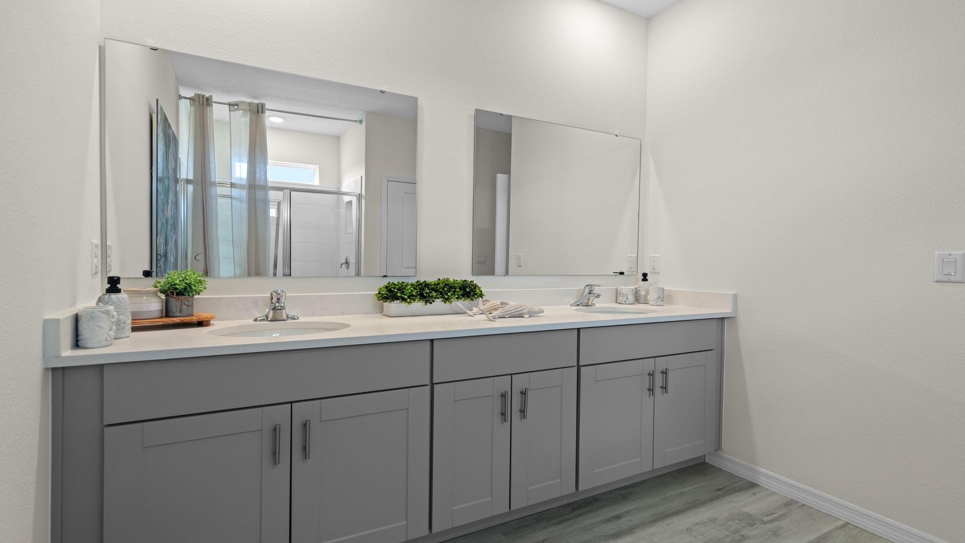 Modern bathroom with double vanity, large wall mirror, cabinets and quartz countertops