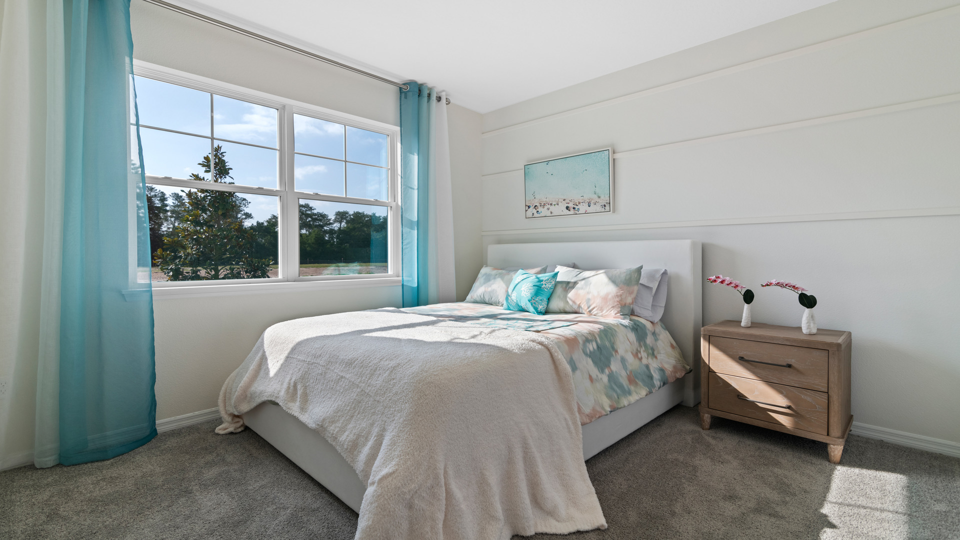 Spacious primary bedroom with king size bed, carpet flooring, natural lighting.