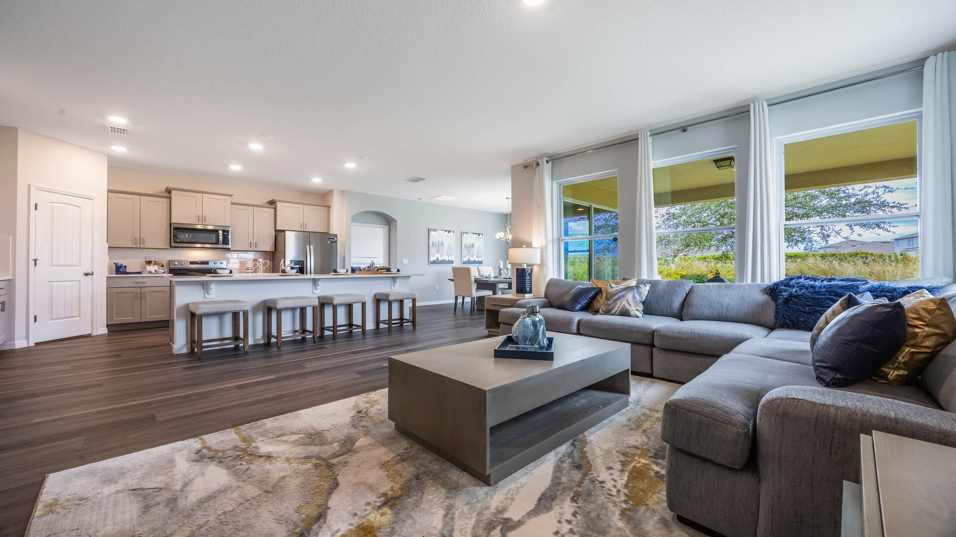 Living area with couch seating, natural lighting, laminate  flooring overseeing entry way.