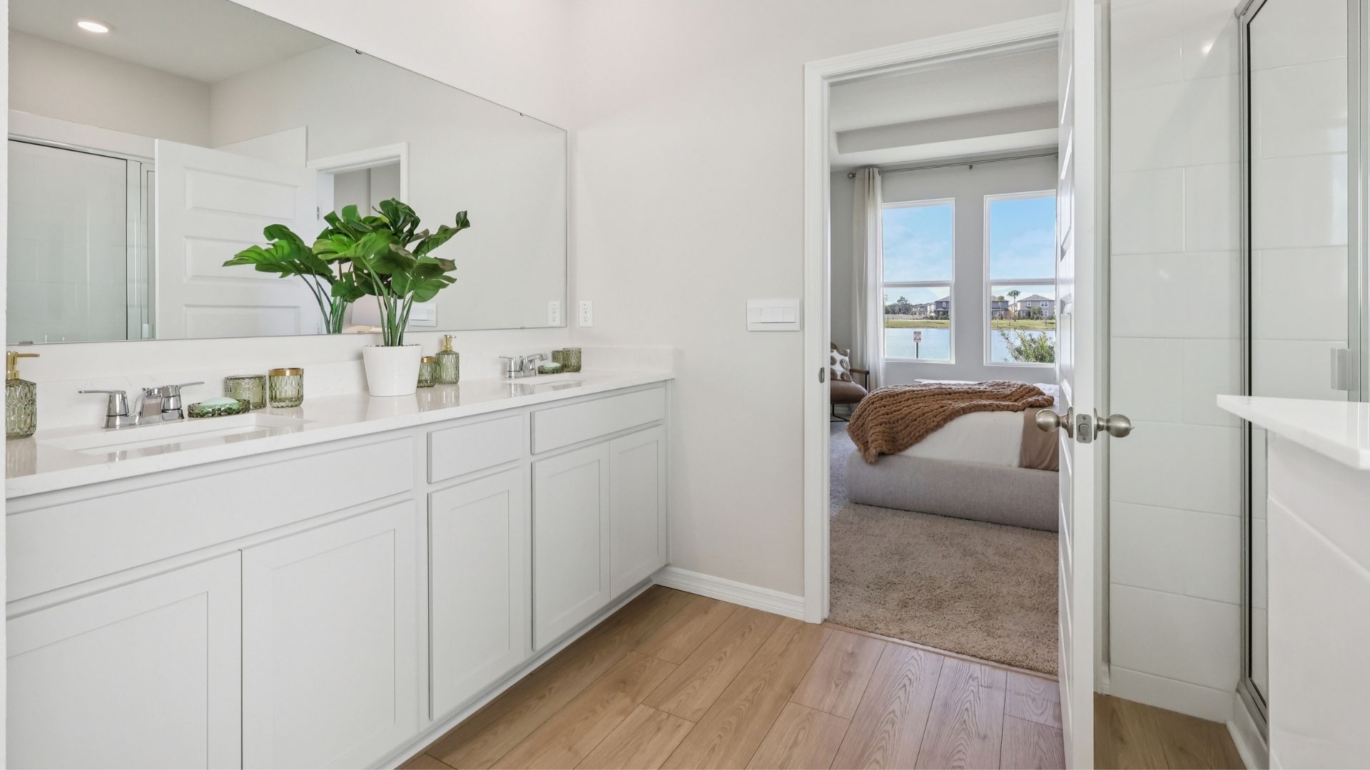 Modern bathroom with double vanity, large wall mirror, cabinets and quartz countertops