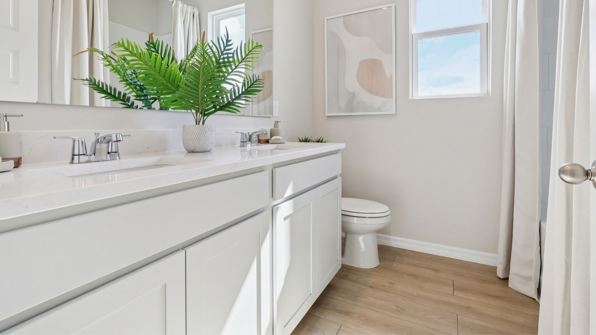 Modern bathroom with double vanity, large wall mirror, cabinets and quartz countertops