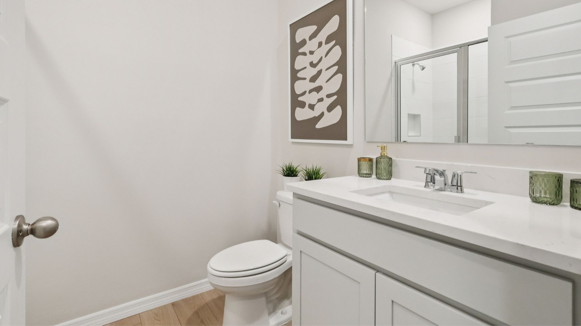 Modern bathroom with double vanity, large wall mirror, cabinets and quartz countertops