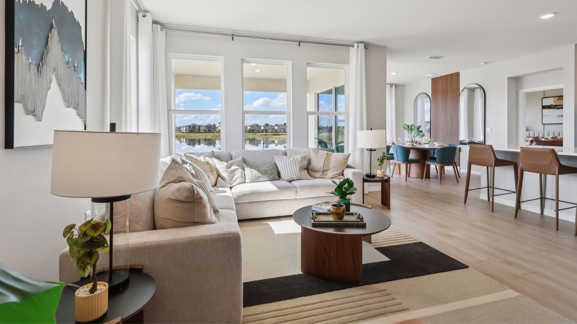 Living area with couch seating, natural lighting, laminate flooring.